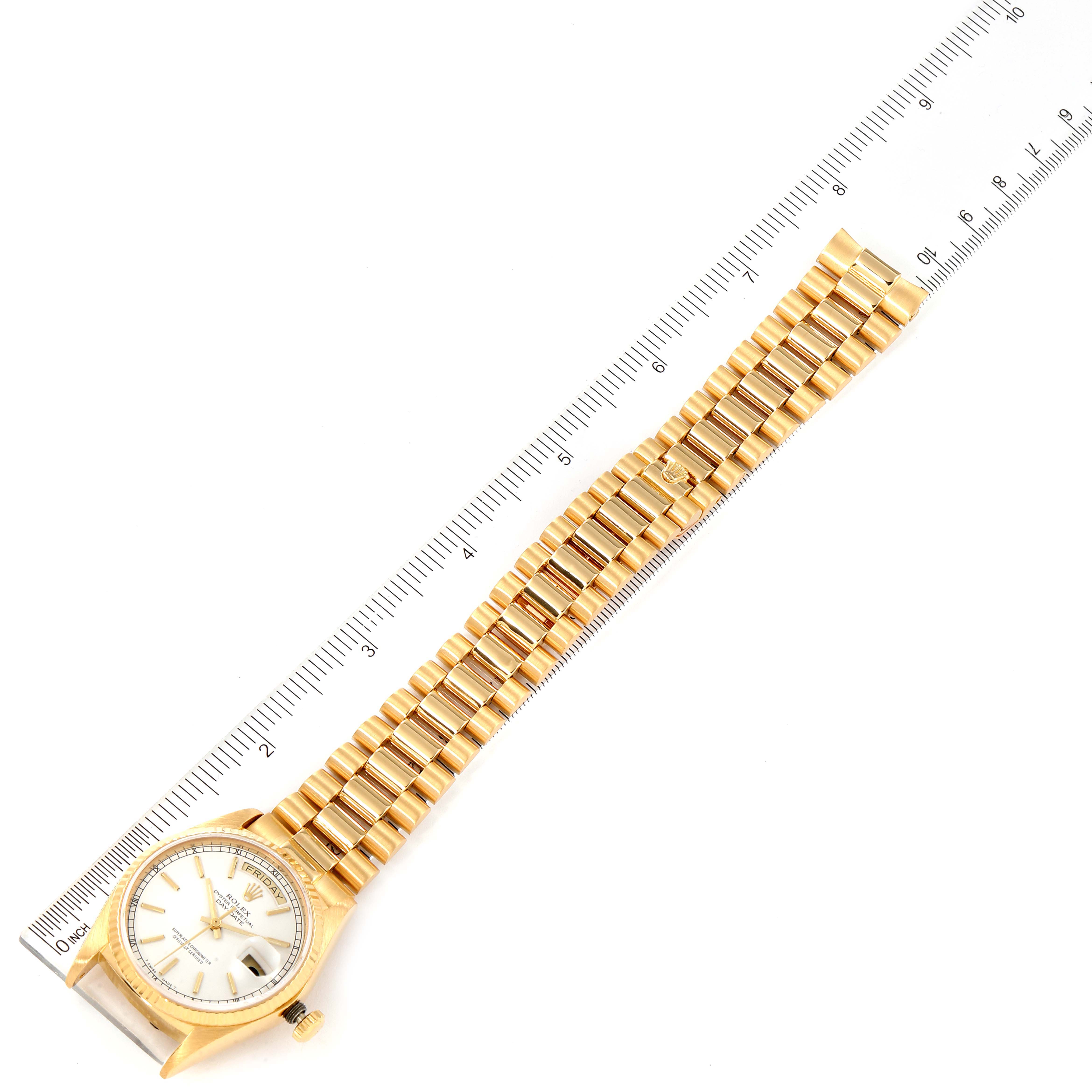 The image shows a Rolex President 18038 Men's Yellow Gold White Dial 18038 Men's Yellow Gold White Dial model watch laid flat with its bracelet and case visible, next to a ruler for scale.