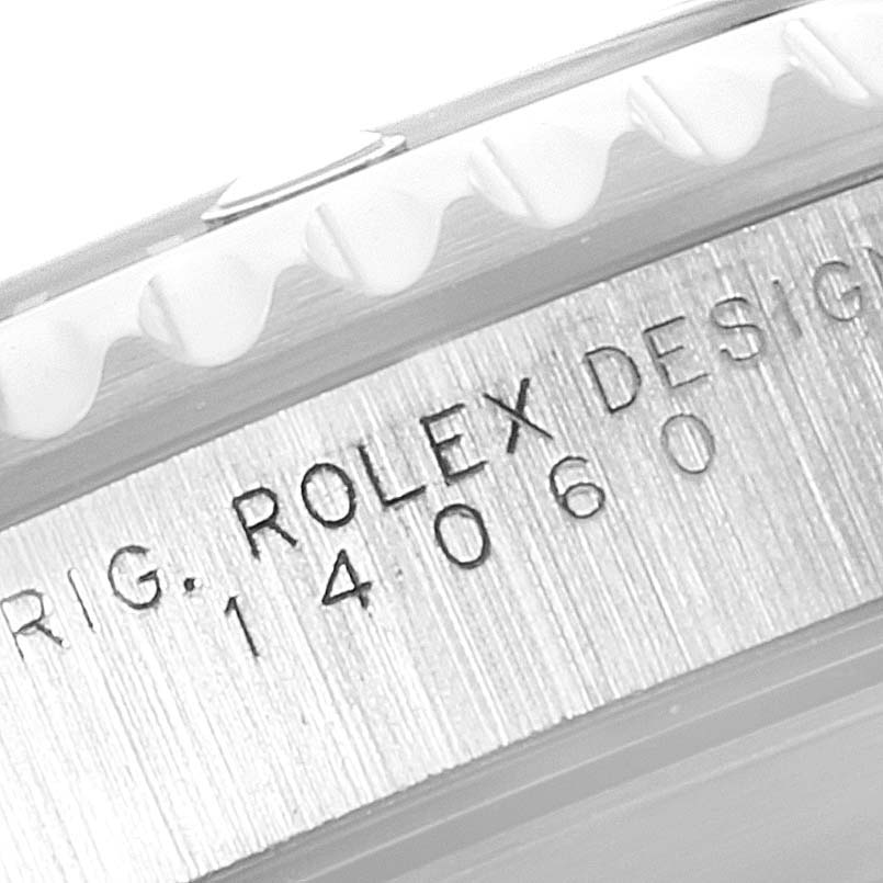 The image shows a close-up of the side of a Rolex Submariner 14060 Men's Stainless Steel Black Dial 14060 Men's Stainless Steel Black Dial, focusing on the model and serial numbers engraved on the case.