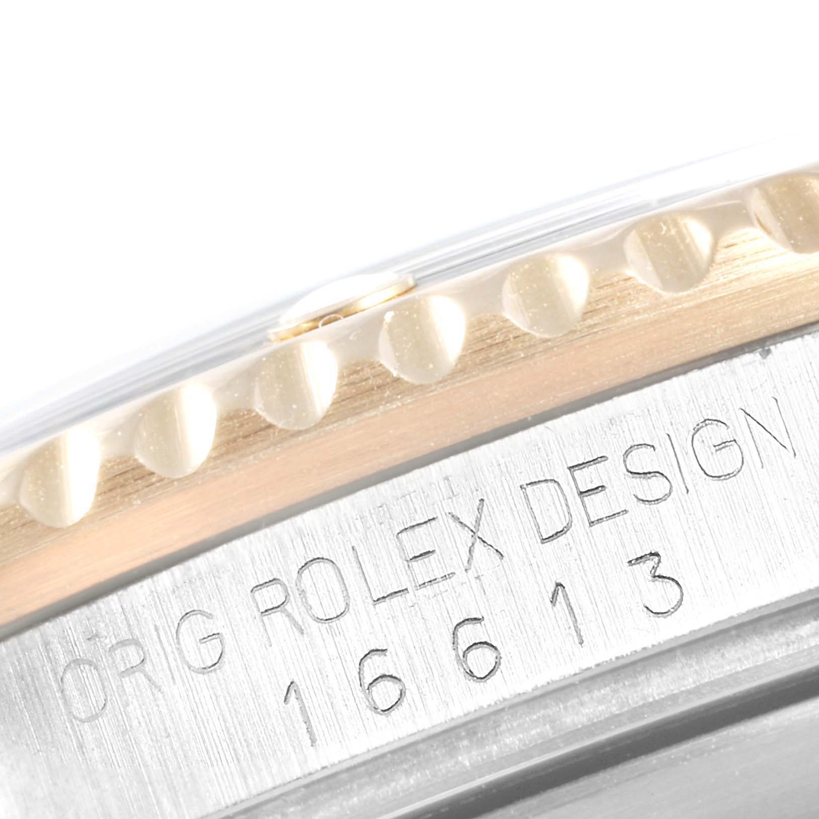 The image shows a close-up of the bezel and engraved case of a Rolex Submariner 16613 Men
s Steel and Gold (two tone) Champagne Dial 16613 Men
s Steel and Gold (two tone) Champagne Dial model 16613.