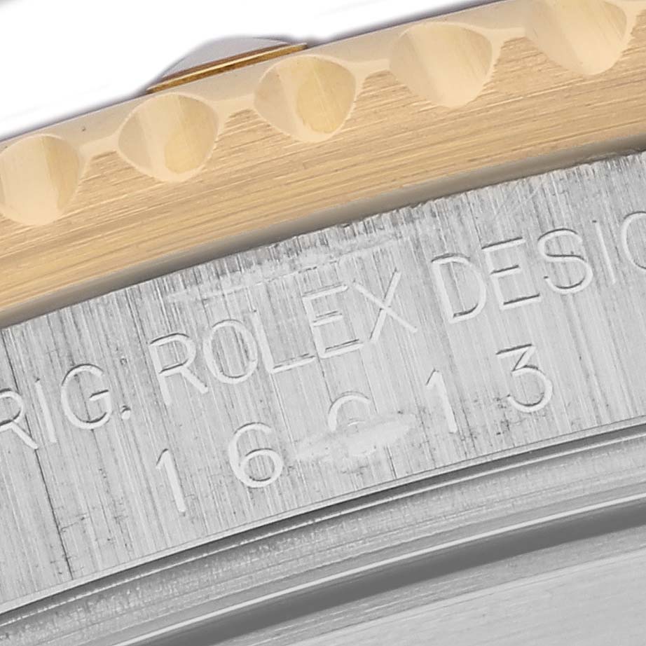 The image shows a close-up of the Submariner model by Rolex, highlighting the bezel and part of the case with engraved text.