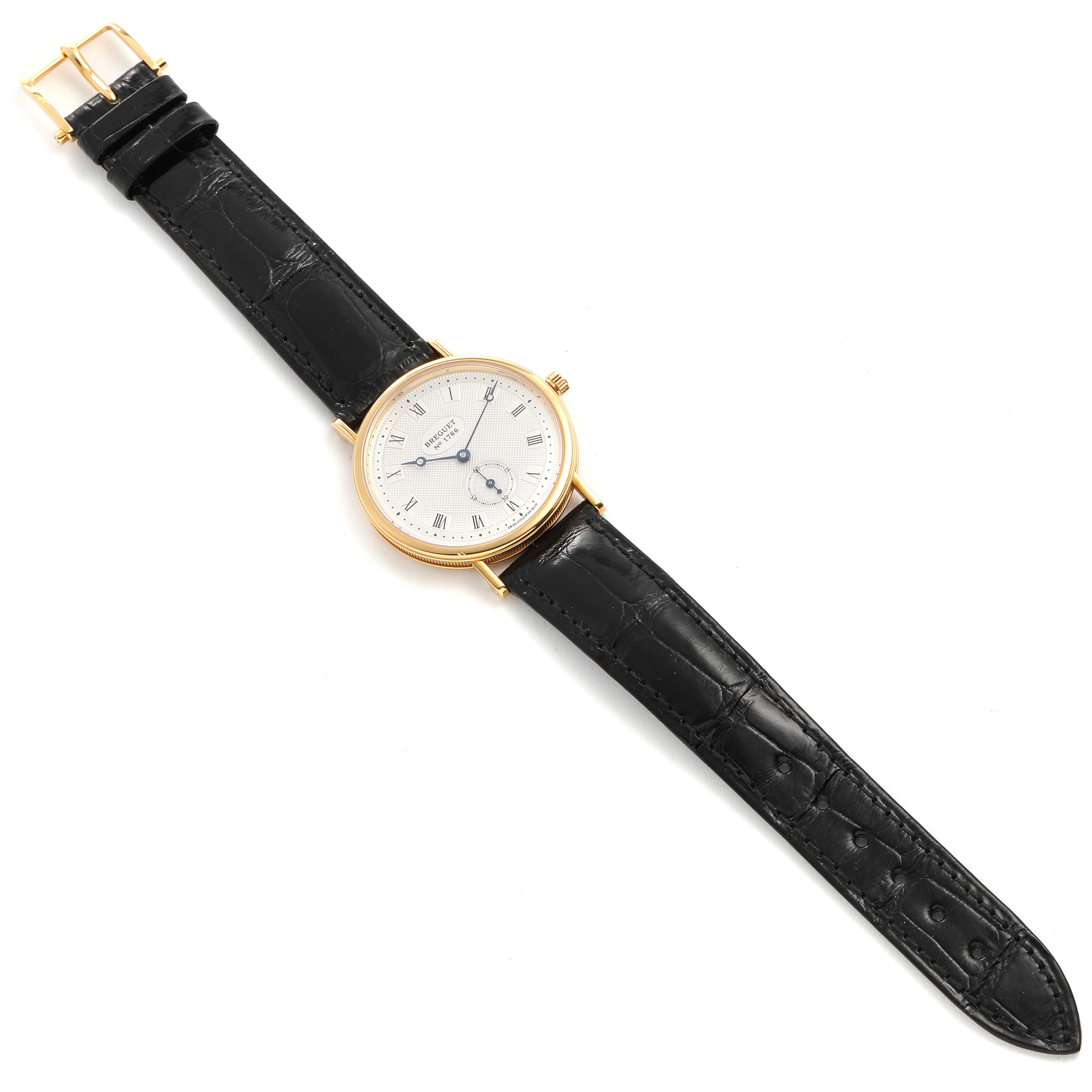 This image shows a Breguet Classique 3910BA/15/286 Men's Yellow Gold Silver Dial 3910BA/15/286 Men's Yellow Gold Silver Dial watch laid flat, featuring a gold bezel, white dial, black leather strap, and visible buckle.