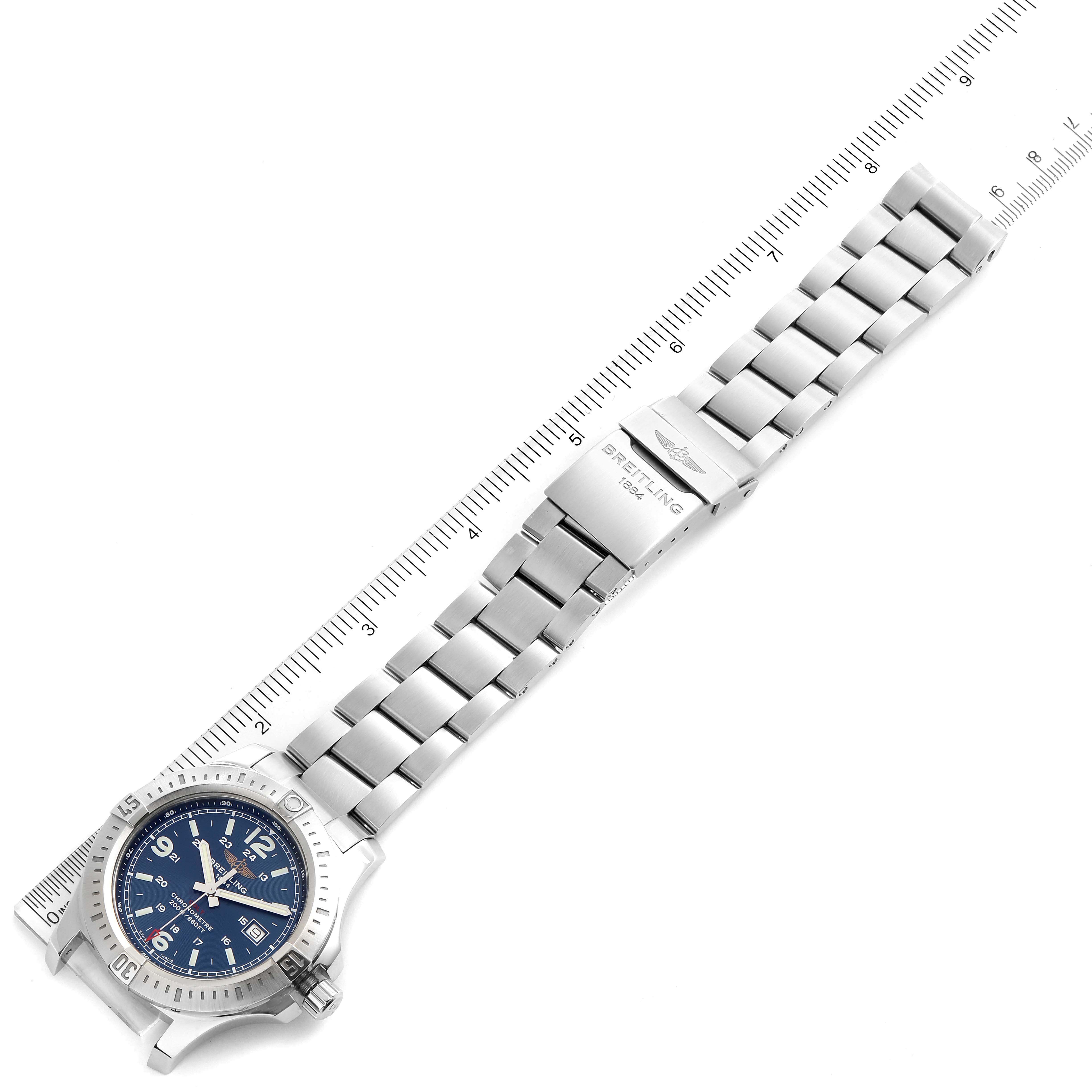 The image shows a Breitling Colt A74388 Men's Stainless Steel Blue Dial A74388 Men's Stainless Steel Blue Dial watch laid flat with the face and stainless steel bracelet fully visible, alongside a measurement scale.