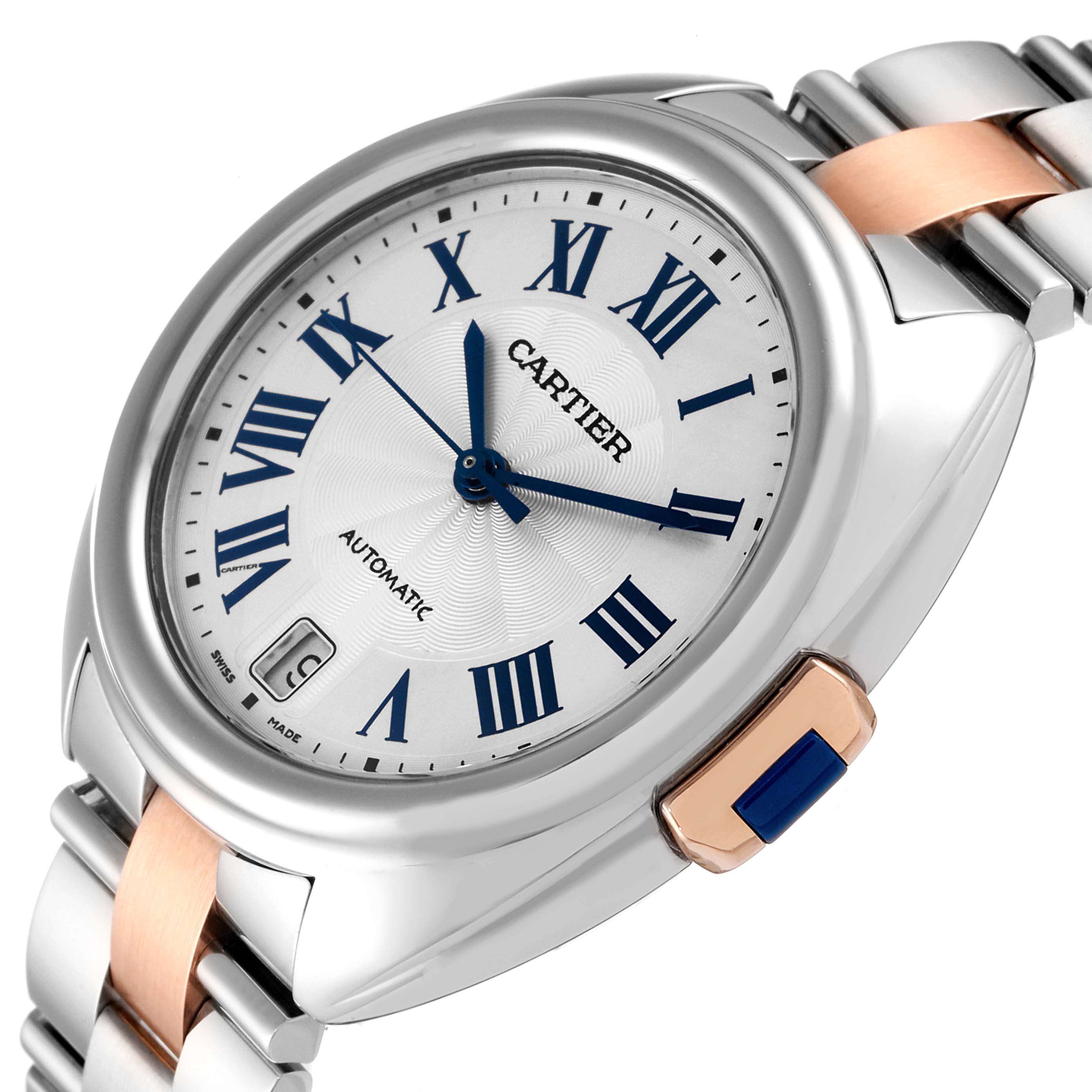 The image showcases a Cartier Clé watch at a tilted angle, highlighting the dial, roman numerals, and part of the bracelet with a blue cabochon crown.