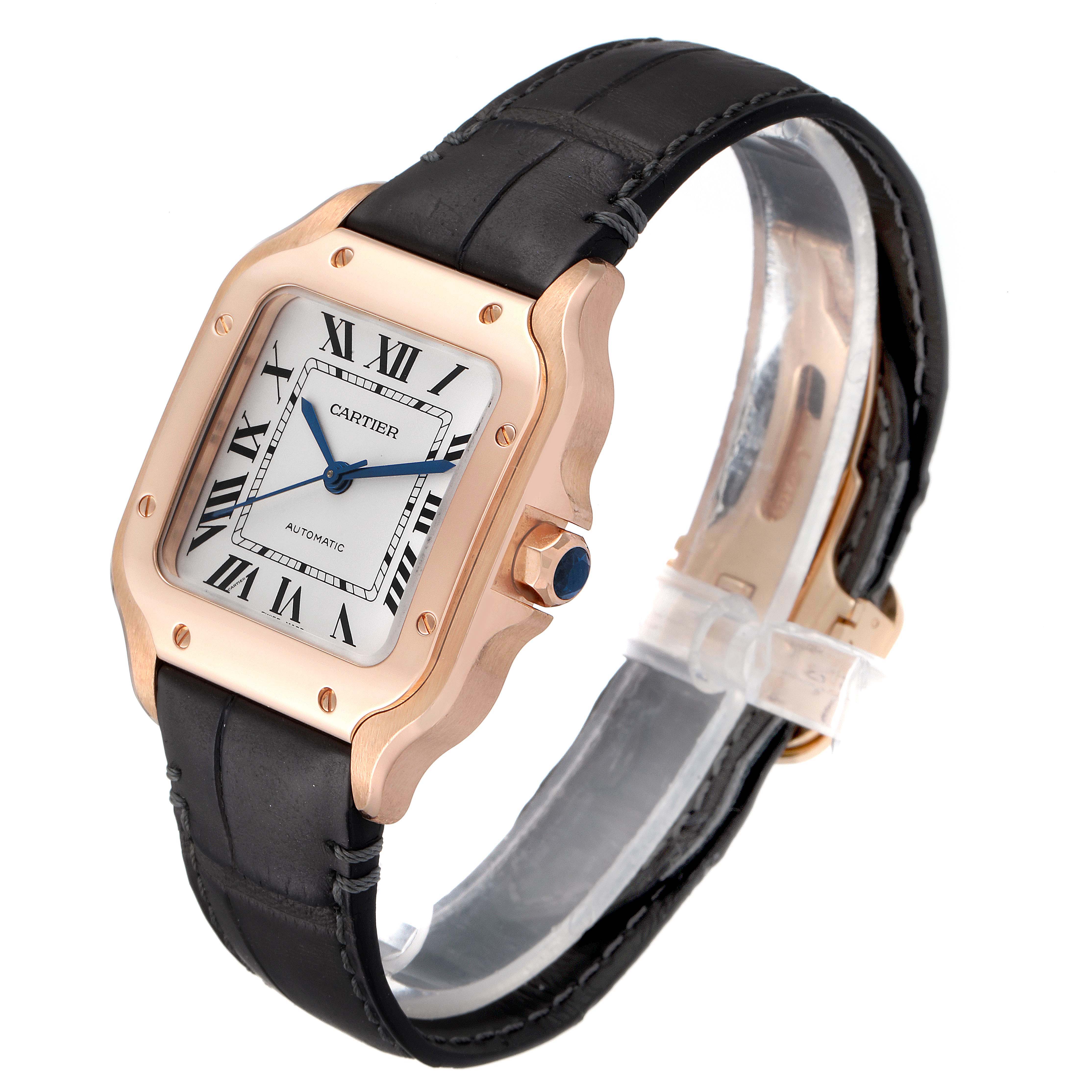 The Cartier Santos WGSA0012 Men's Rose Gold Silver Dial WGSA0012 Men's Rose Gold Silver Dial watch is shown at a tilted angle, highlighting its face, bezel, crown, and leather strap.