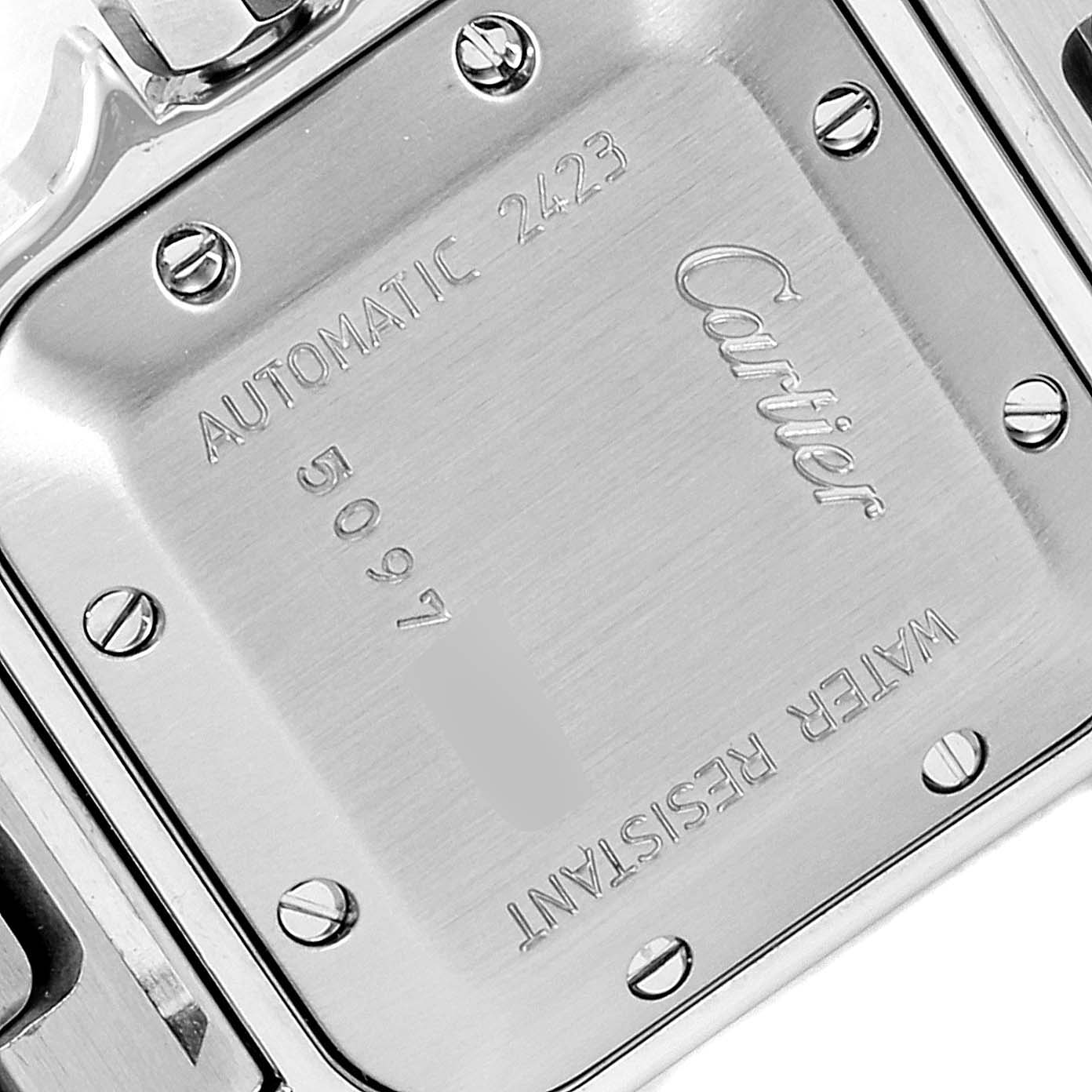The image shows the back case of a Santos model by Cartier, displaying engraved details and screws.