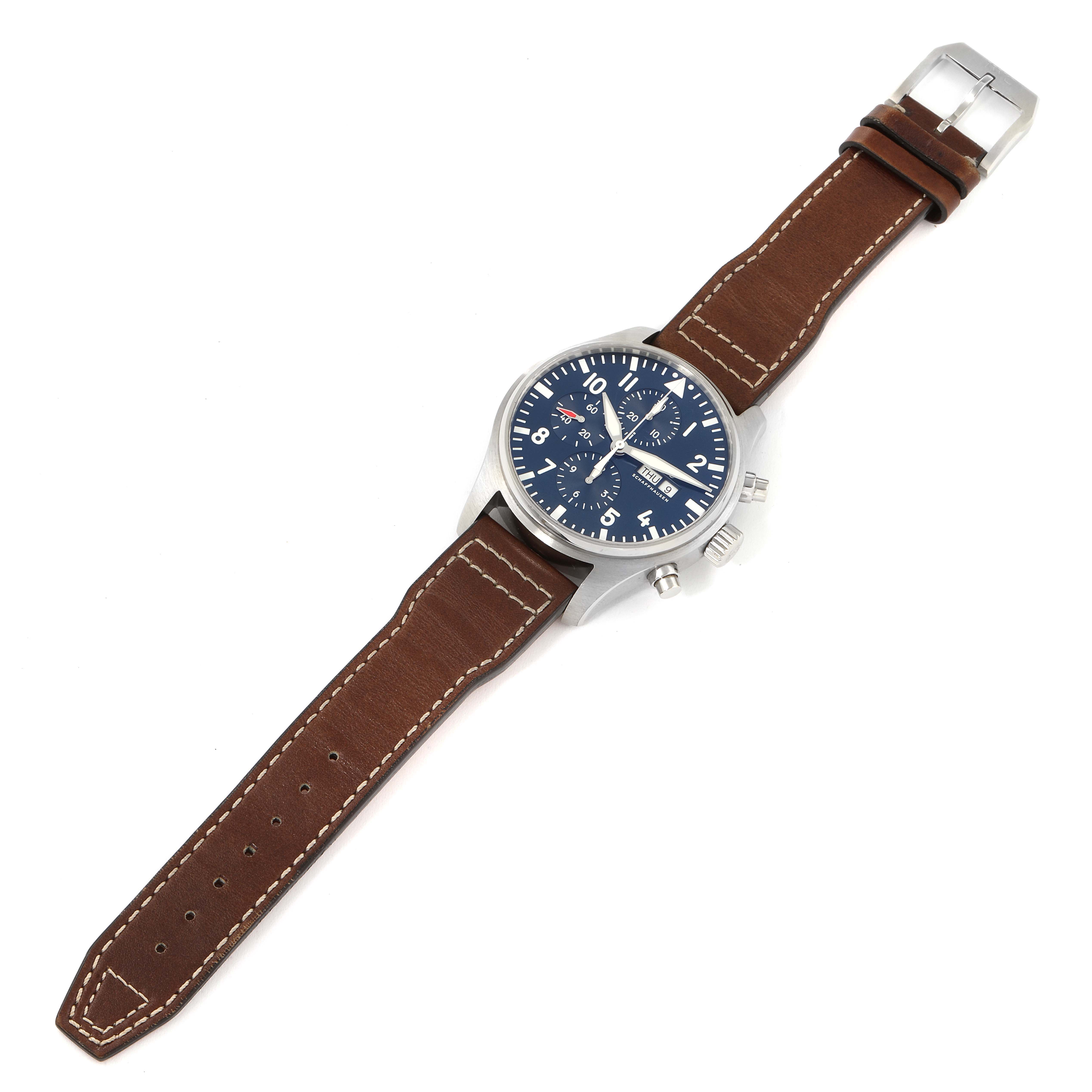The image shows an IWC Pilot IW377714 Men's Stainless Steel Blue Dial IW377714 Men's Stainless Steel Blue Dial model watch from a top-down angle, displaying its dial, case, crown, and brown leather strap.