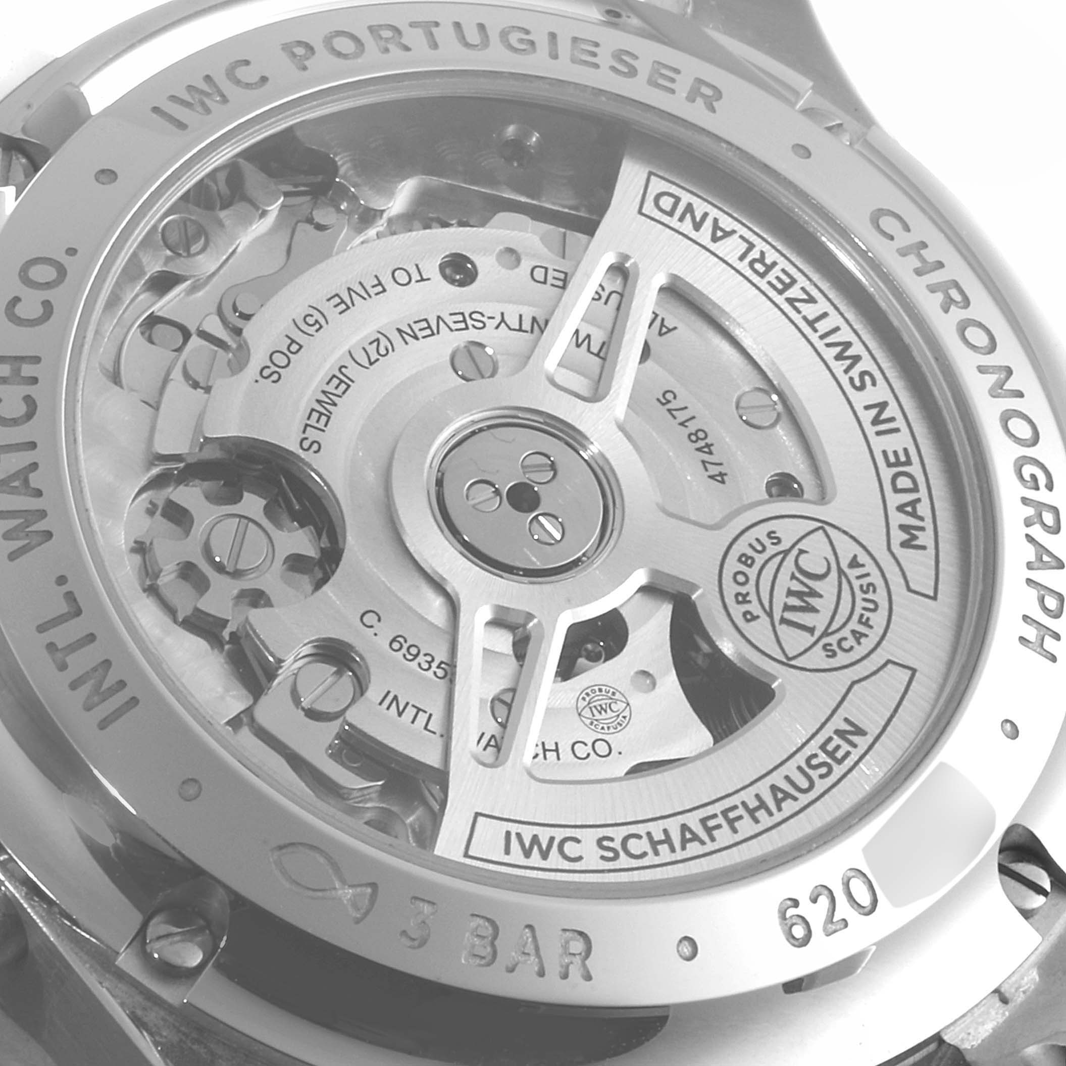 The image shows the back view of an IWC Portuguese IW371605 Men's Stainless Steel Silver Dial IW371605 Men's Stainless Steel Silver Dial Chronograph, highlighting its intricate mechanical movements and engravings.