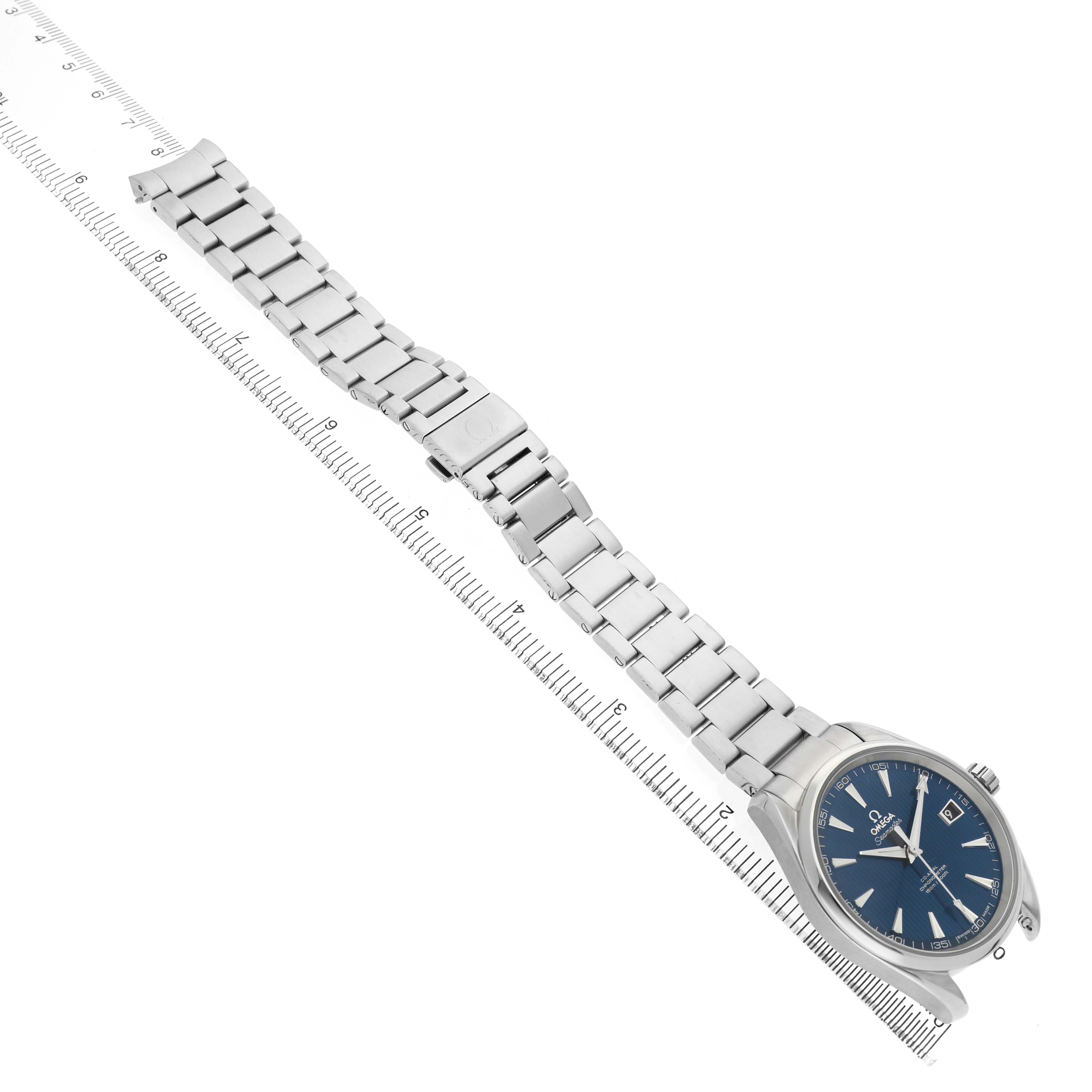 The Omega Aqua Terra 231.10.42.21.03.001 Men's Stainless Steel Blue Dial watch is shown from an angled top view, highlighting the face, bracelet, and clasp against a ruler.