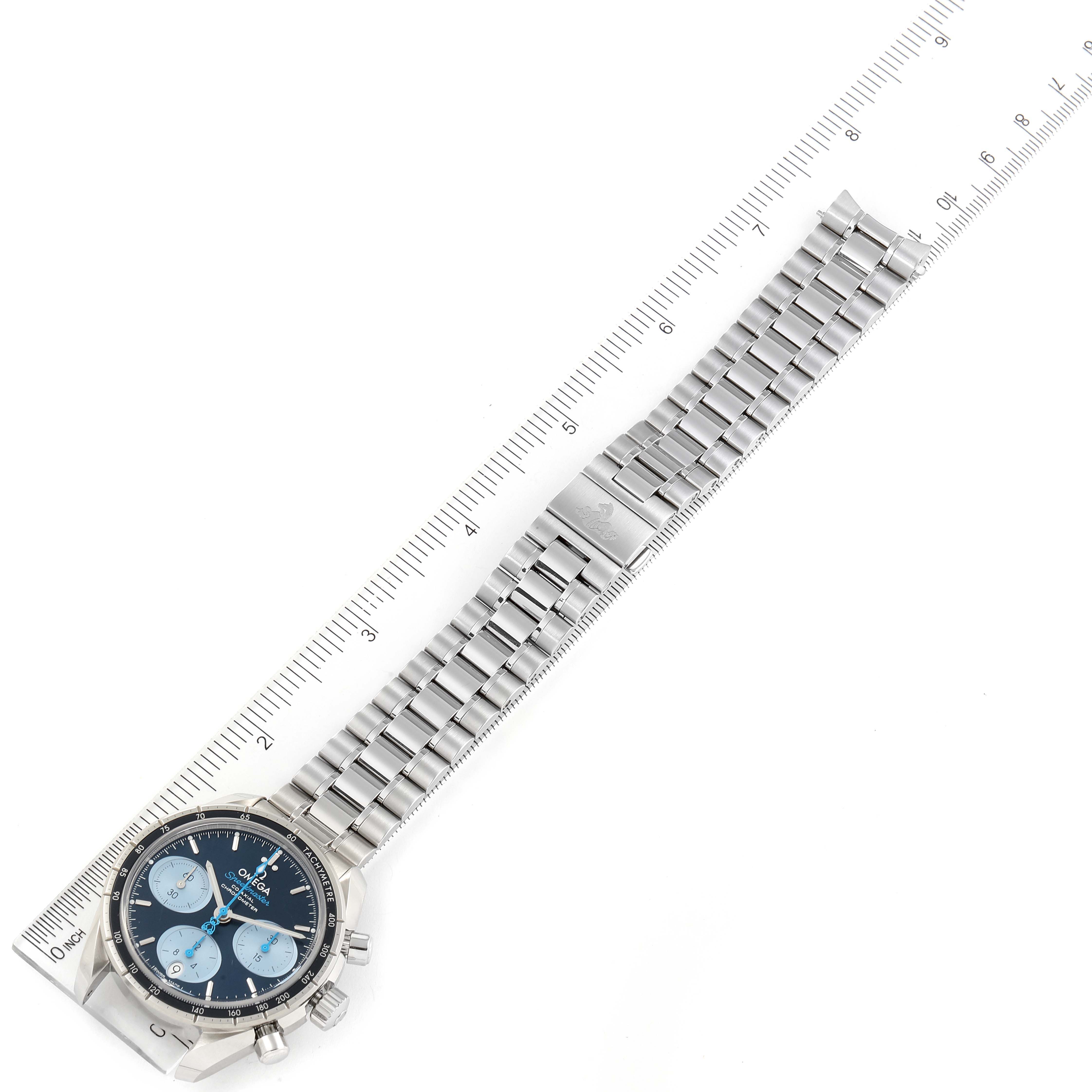 The Omega Speedmaster 324.30.38.50.03.002 Men's Stainless Steel Blue Dial 324.30.38.50.03.002 Men's Stainless Steel Blue Dial watch is shown from an overhead angle with its bracelet alongside a ruler for scale.