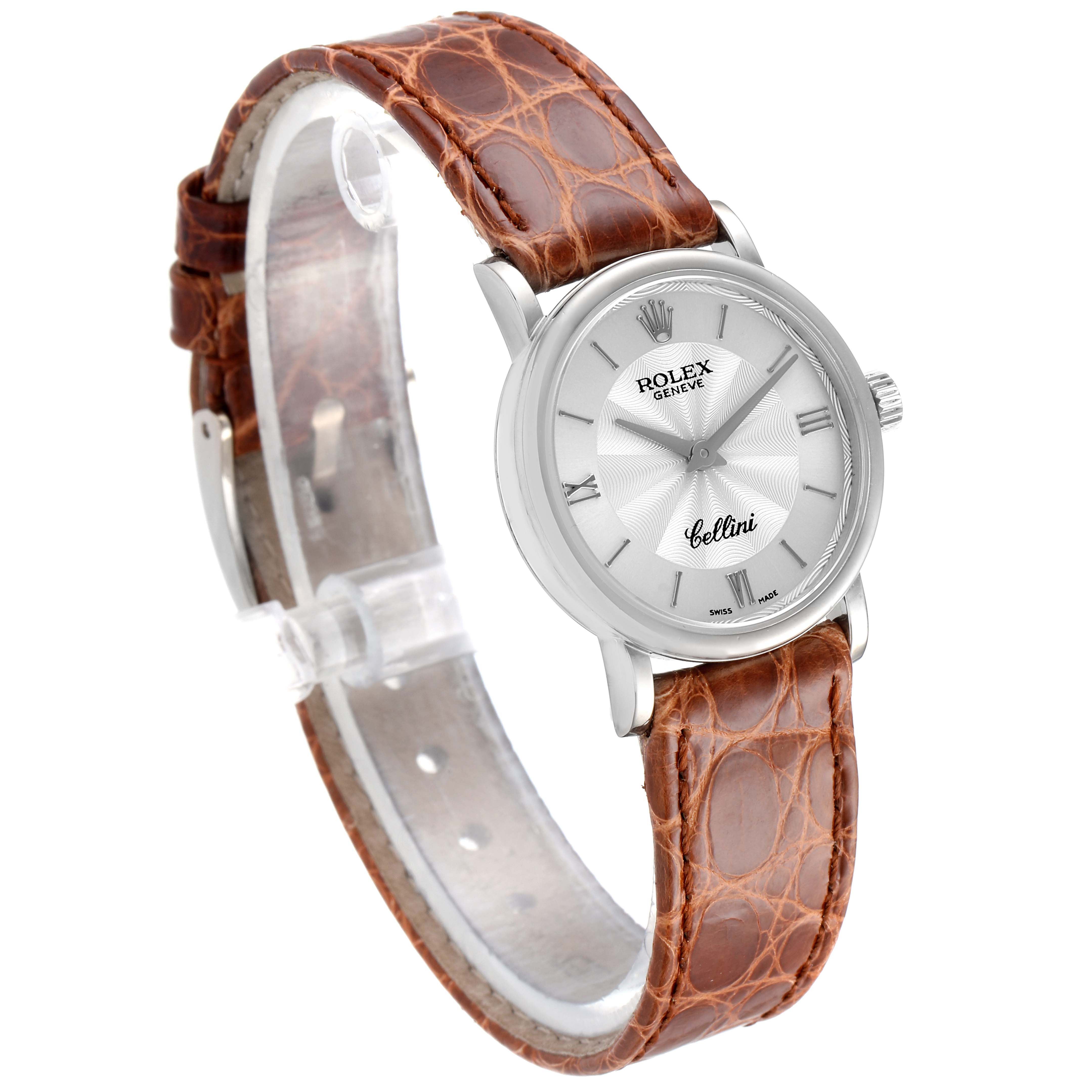 The Rolex Cellini 6110 Women's White Gold Silver Dial 6110 Women's White Gold Silver Dial watch is shown from an angled side view, featuring its face and brown leather strap.