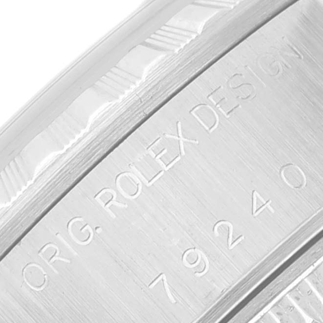 The image shows a close-up angle of the Rolex Datejust 79240 Women's Stainless Steel Black Dial 79240 Women's Stainless Steel Black Dial model's case with the engraving "ORIG. ROLEX DESIGN" and a serial number.