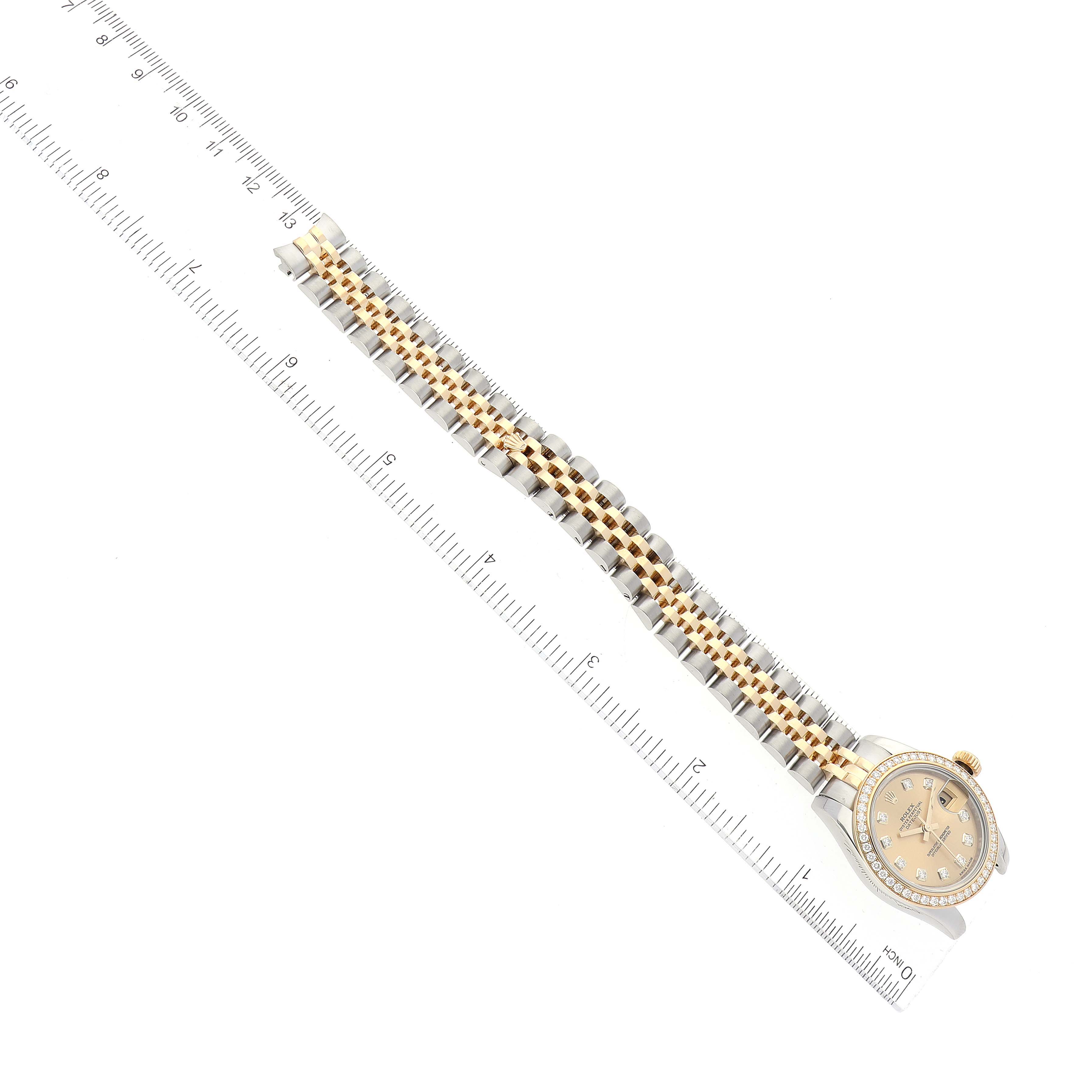 The Rolex Datejust 179383 Women's Steel and Gold (two tone) Champagne Dial 179383 Women's Steel and Gold (two tone) Champagne Dial watch is shown from a top view, featuring the face and entire two-tone bracelet next to a ruler.