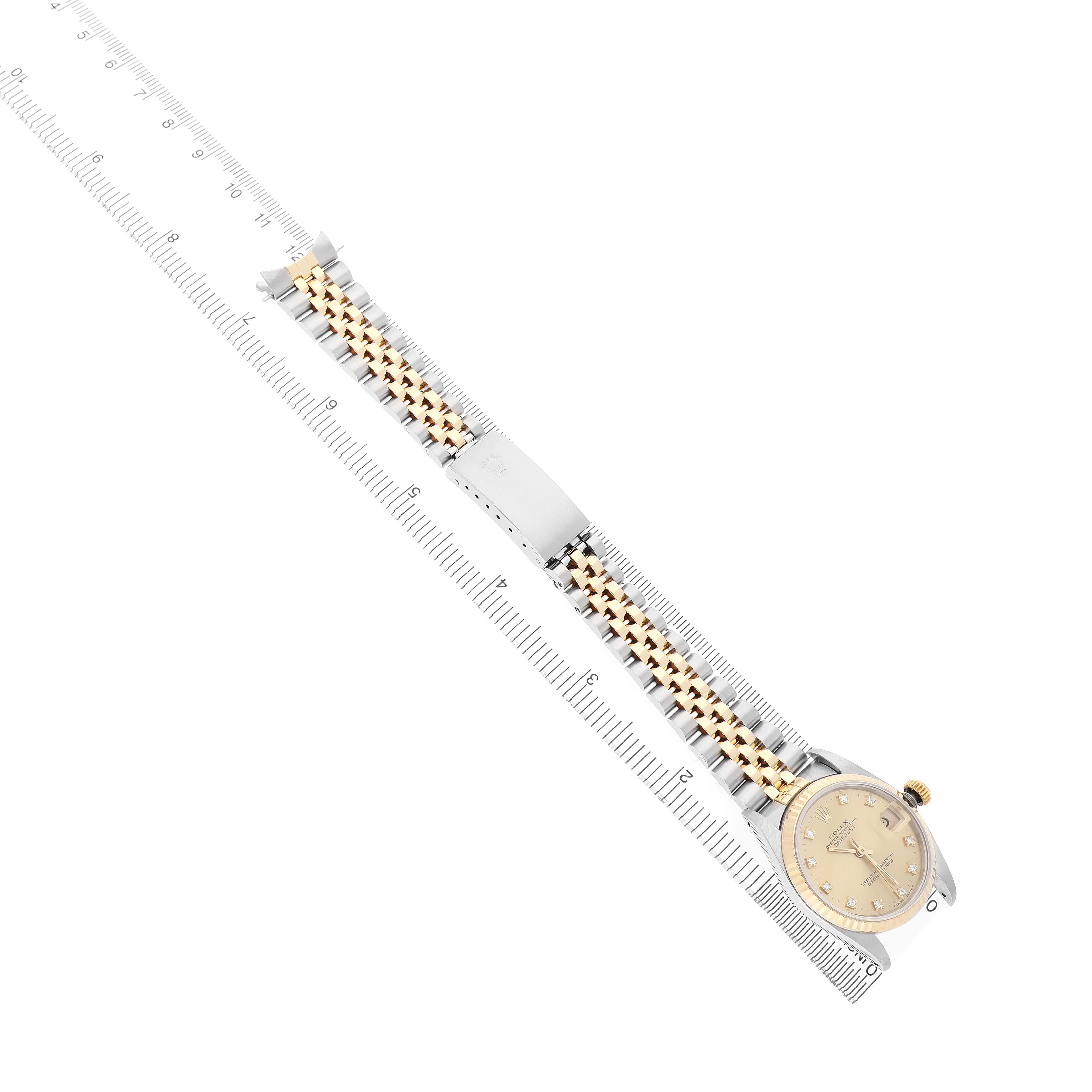 The image shows a Rolex Datejust 68273 Women's Steel and Gold (two tone) Champagne Dial watch at an angle that highlights its bracelet and face, alongside a ruler.