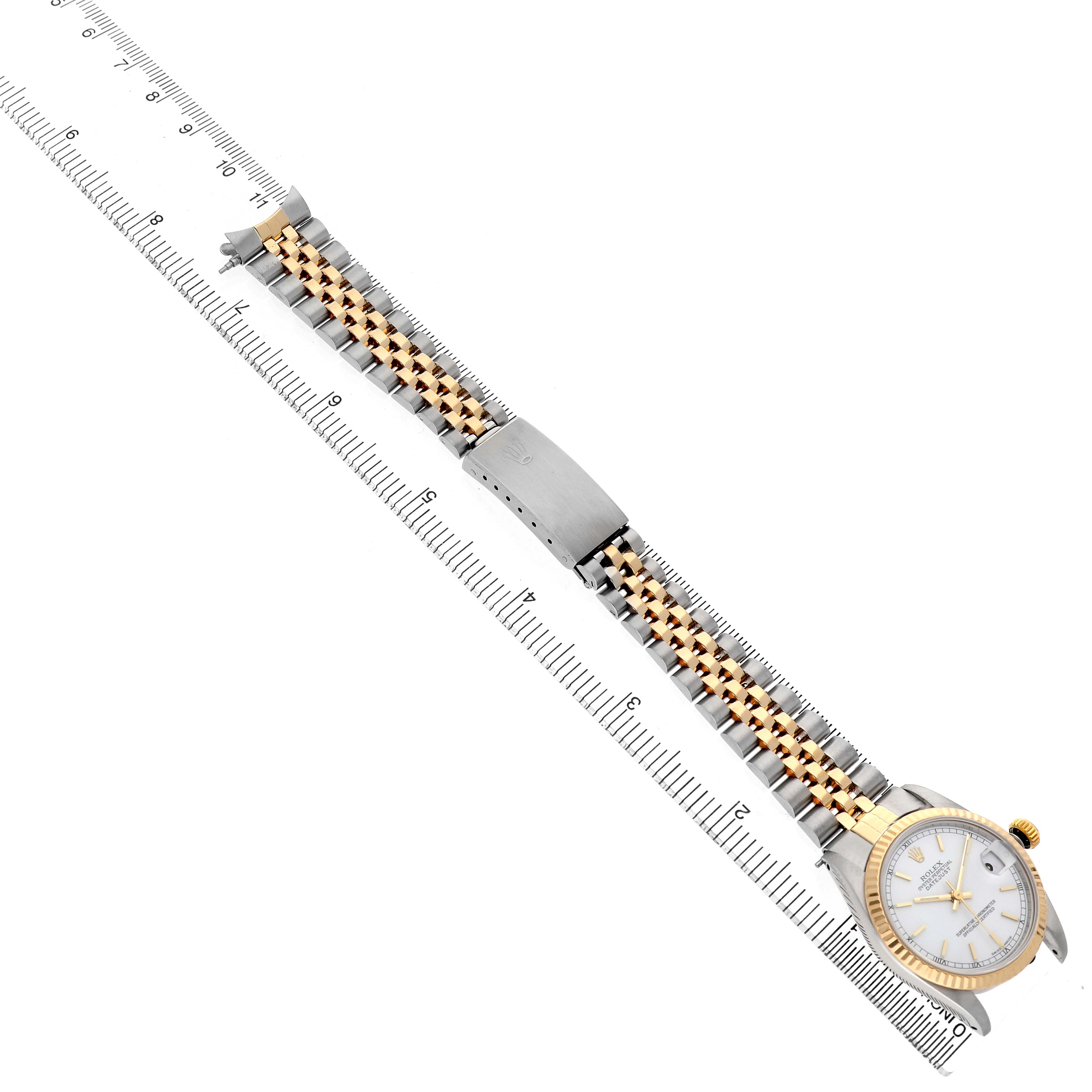 The Rolex Mid-Size 68273 Women's Stainless Steel White Dial watch is shown from a top-down angle, highlighting the dial, bezel, and full bracelet alongside a ruler.