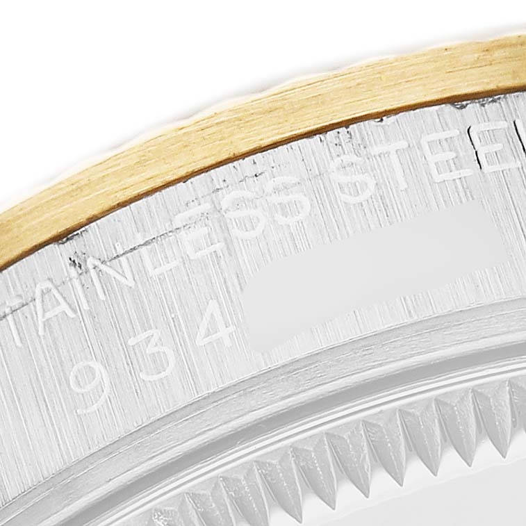 The image shows a close-up of the bezel and part of the case of a Rolex Mid-Size 68273 Women's Stainless Steel White Dial watch, highlighting the stainless steel and gold details.