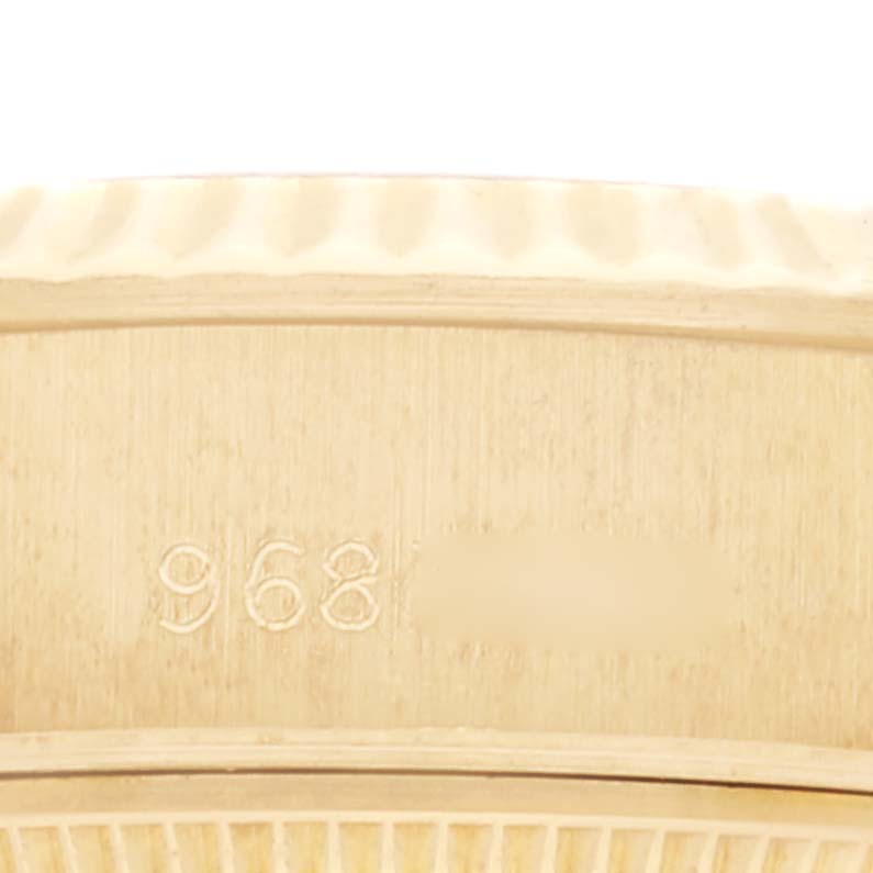 This close-up image shows the engraved bezel of a Rolex President 69178 Women's Yellow Gold Black Dial 69178 Women's Yellow Gold Black Dial model watch.