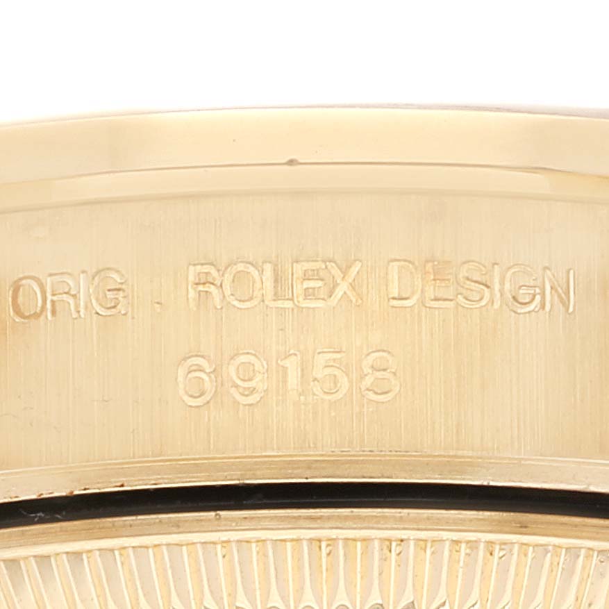 This close-up image shows the engraving on the case side of the Rolex President 69158 Women's Yellow Gold Champagne Dial 69158 Women's Yellow Gold Champagne Dial model watch.