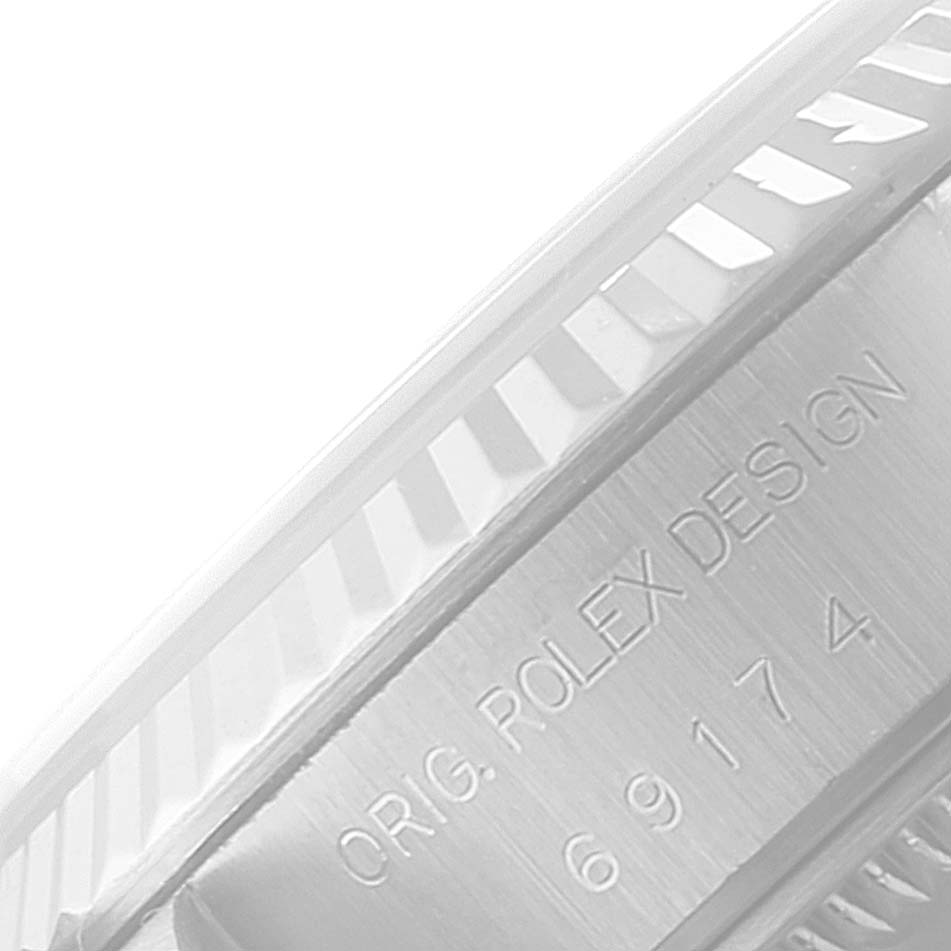 This close-up of the Rolex Datejust 69174 Women's Stainless Steel Black Dial 69174 Women's Stainless Steel Black Dial watch shows the fluted bezel and a portion with the engraving "ORIG. ROLEX DESIGN" and the model number.