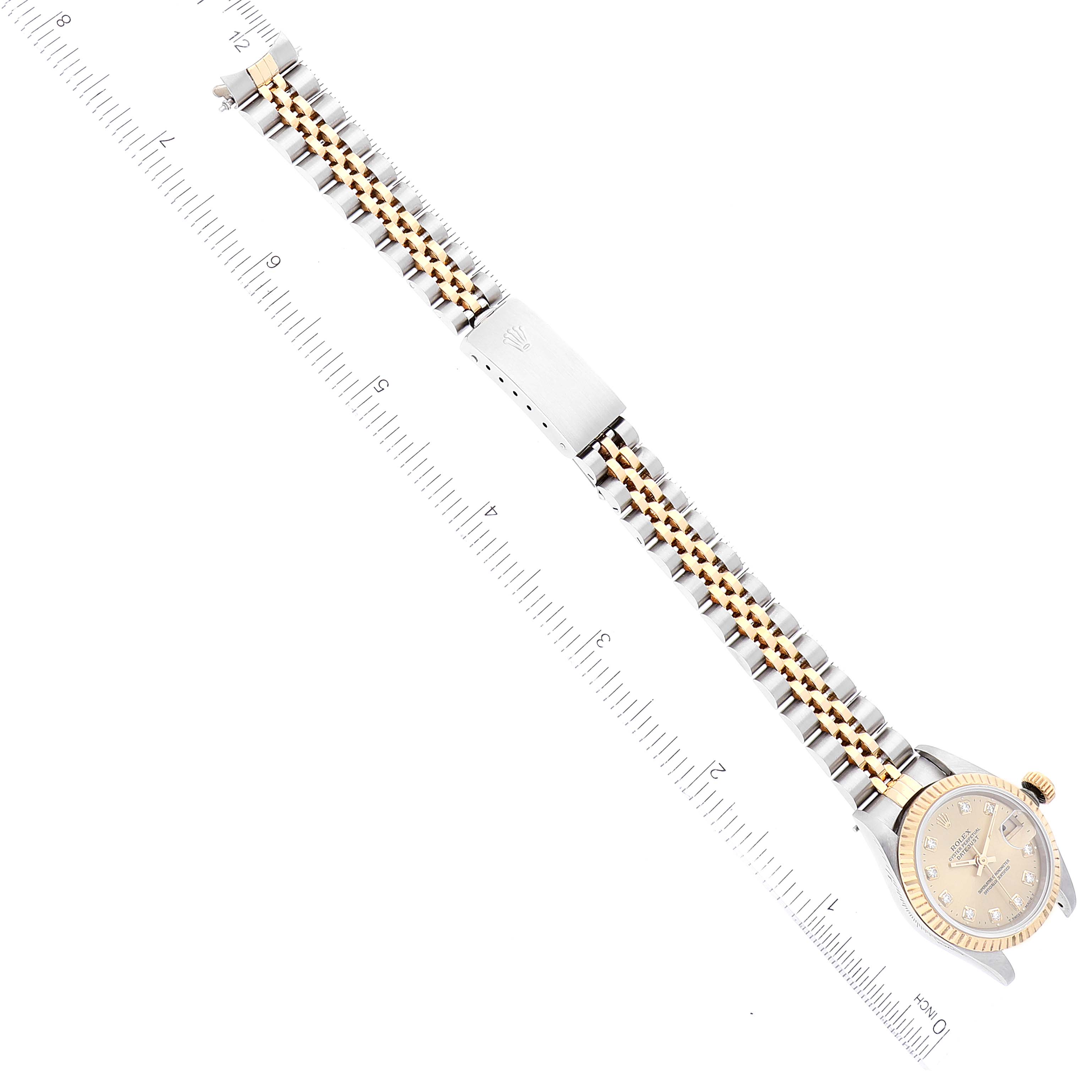 The image shows a top-down view of a Rolex Datejust 69173 Women's Steel and Gold (two tone) Champagne Dial 69173 Women's Steel and Gold (two tone) Champagne Dial watch focused on the clasp and bracelet with a ruler for scale.