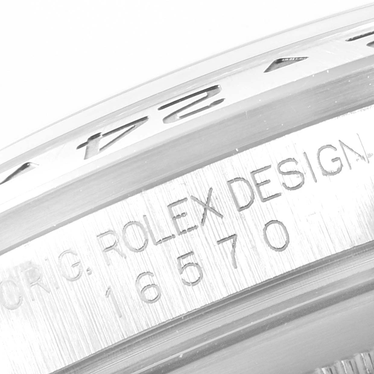 The image shows a close-up of the engravings on the bezel and case of a Rolex Explorer 16570 Men
s Stainless Steel Black Dial 16570 Men
s Stainless Steel Black Dial model watch.