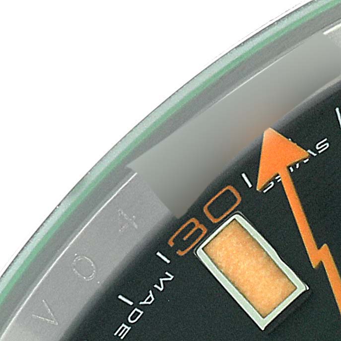 The image shows a close-up of the dial of a Rolex Milgauss 116400 Men's Stainless Steel Black Dial 116400 Men's Stainless Steel Black Dial watch, specifically the 30-minute mark and part of the orange second hand.