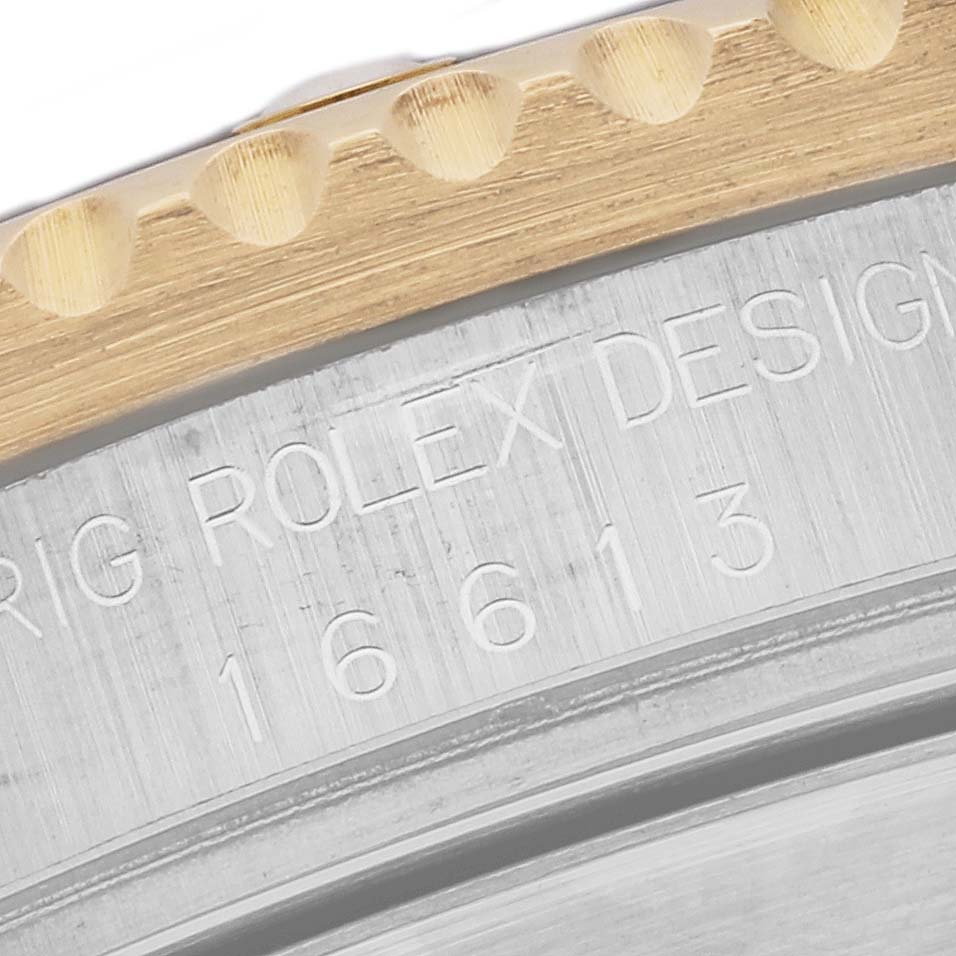This close-up image shows the engraved bezel and model number 16613 of a Rolex Submariner 16613 Men's Steel and Gold (two tone) Blue Dial 16613 Men's Steel and Gold (two tone) Blue Dial watch.