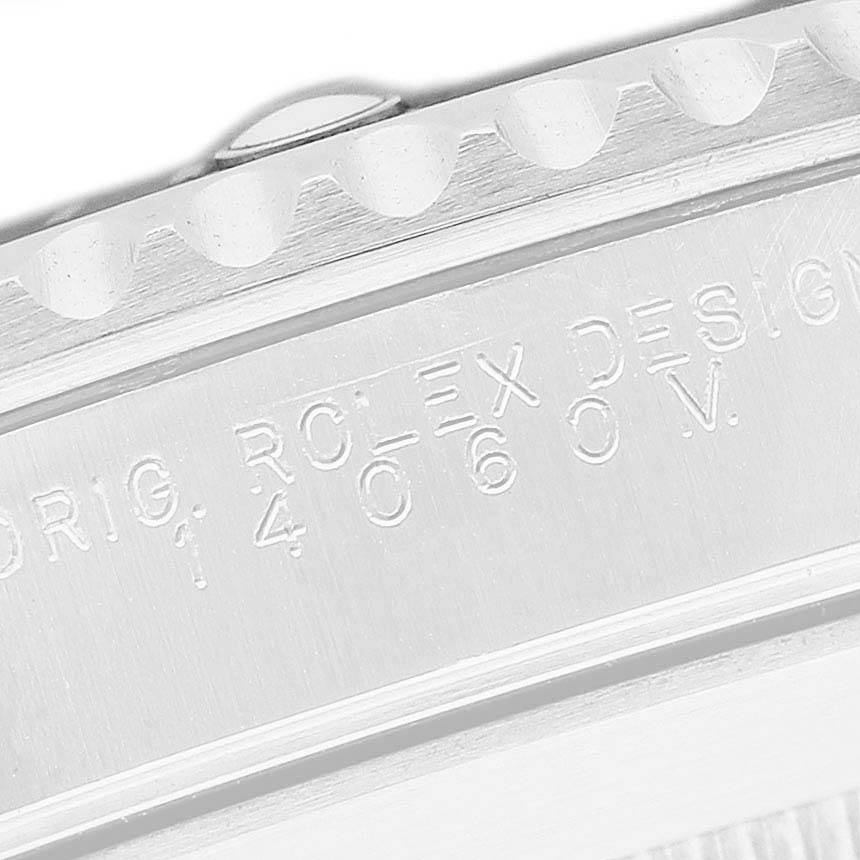 The image shows a close-up of the engraved side detailing of the Rolex Submariner 14060M Men's Stainless Steel Black Dial watch, including the bezel and case side.