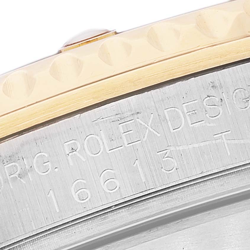 The image shows a close-up of the bezel and engraved side of a Rolex Submariner 16613 Men's Steel and Gold (two tone) Champagne Dial 16613 Men's Steel and Gold (two tone) Champagne Dial watch case.