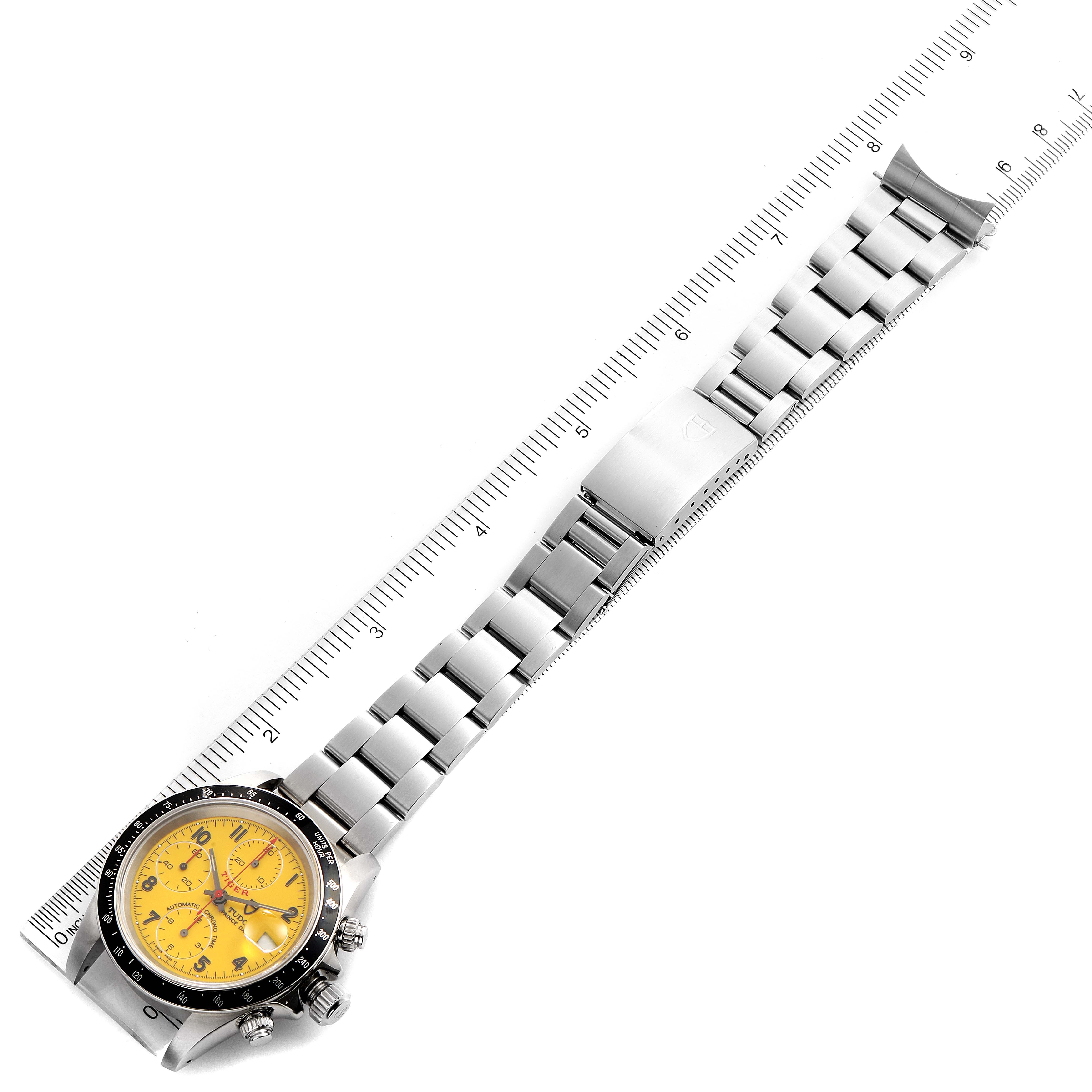 The image shows a top-down view of a Tudor Tiger 79260 Men's Stainless Steel Yellow Dial 79260 Men's Stainless Steel Yellow Dial model watch with a yellow dial and stainless steel bracelet next to a ruler.