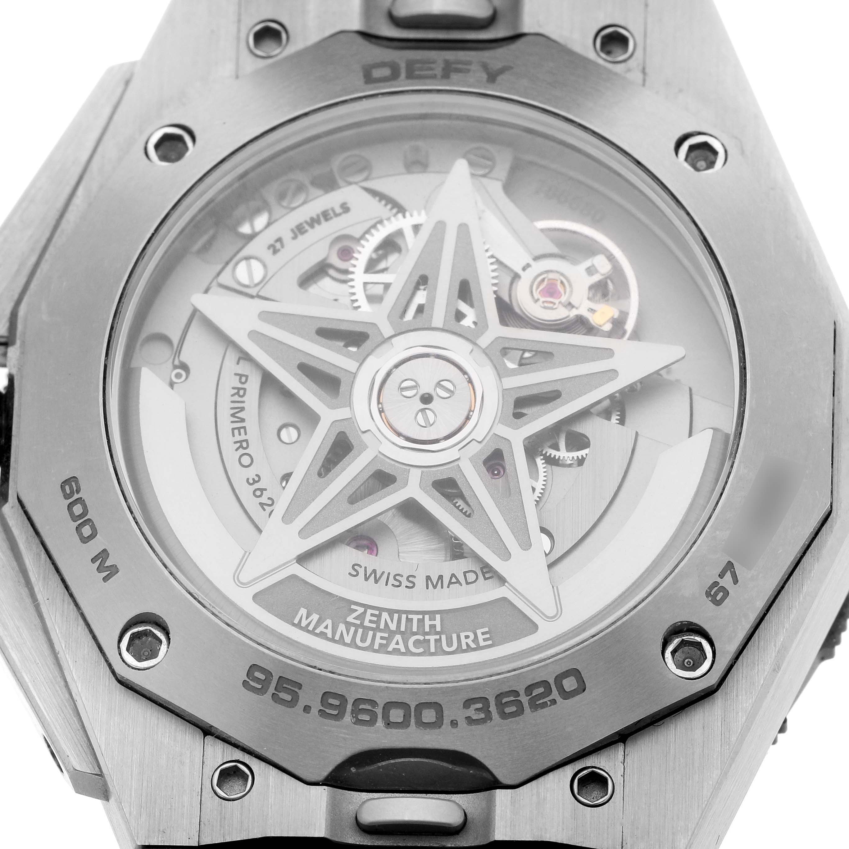 The image shows the back of a Zenith Defy 95.9600.3620/21.I300 Men's Titanium Black Dial watch, highlighting the movement and visible rotor inside an octagonal case.