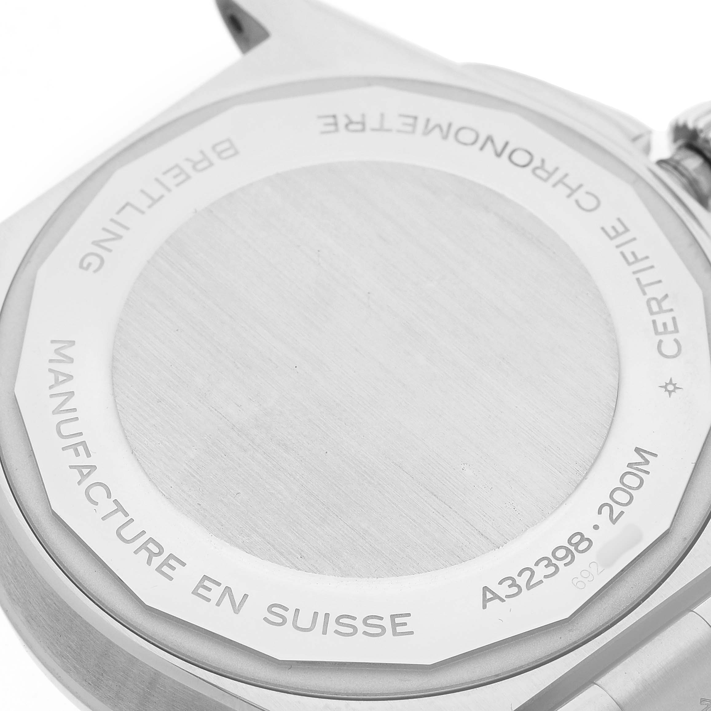 The image shows the back case of a Breitling Chronomat A32398 Men's Stainless Steel White Dial watch, focusing on engraved details and the edging.