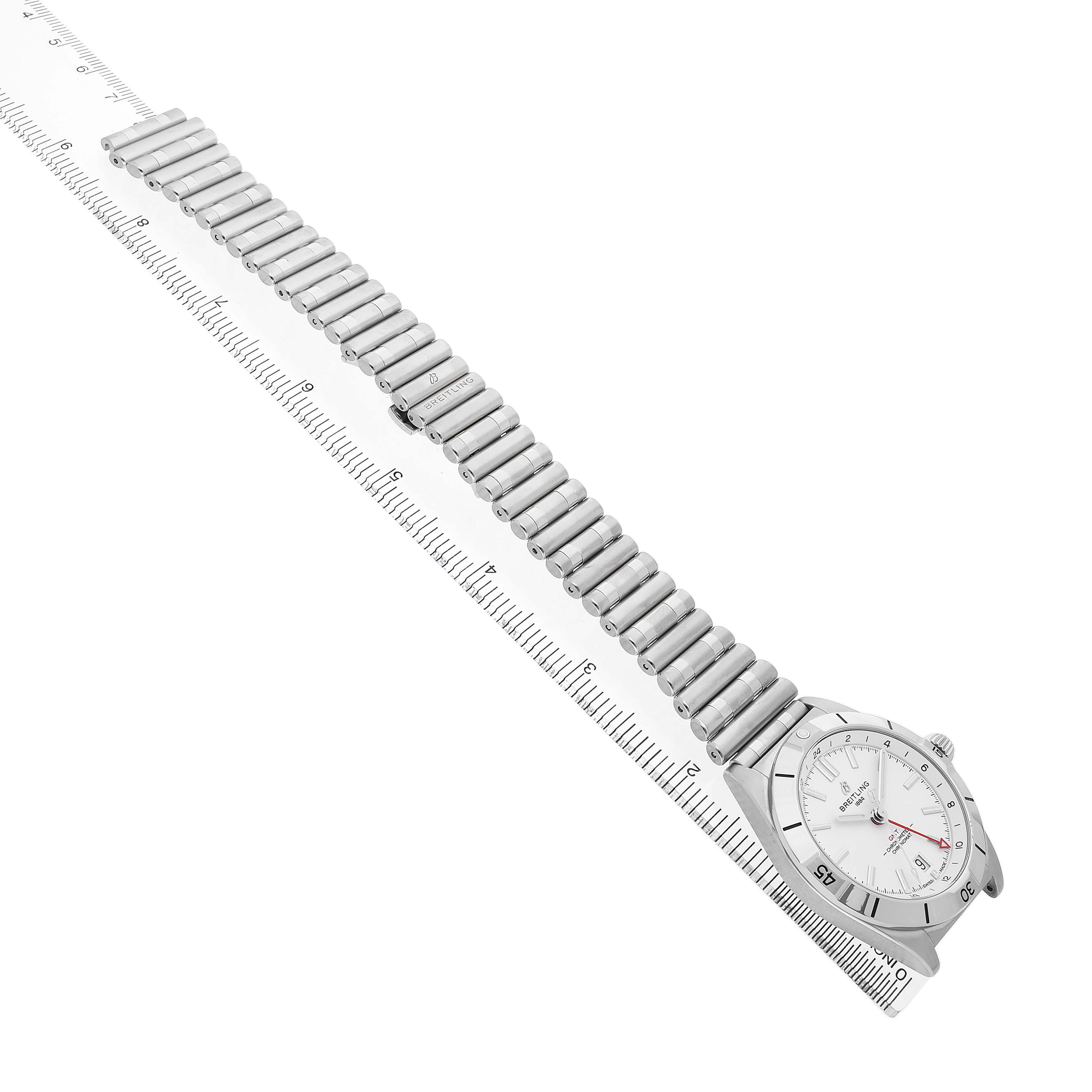 The Breitling Chronomat A32398 Men's Stainless Steel White Dial watch is shown from a top-down angle, displaying the entire bracelet and face alongside a ruler for measurement.