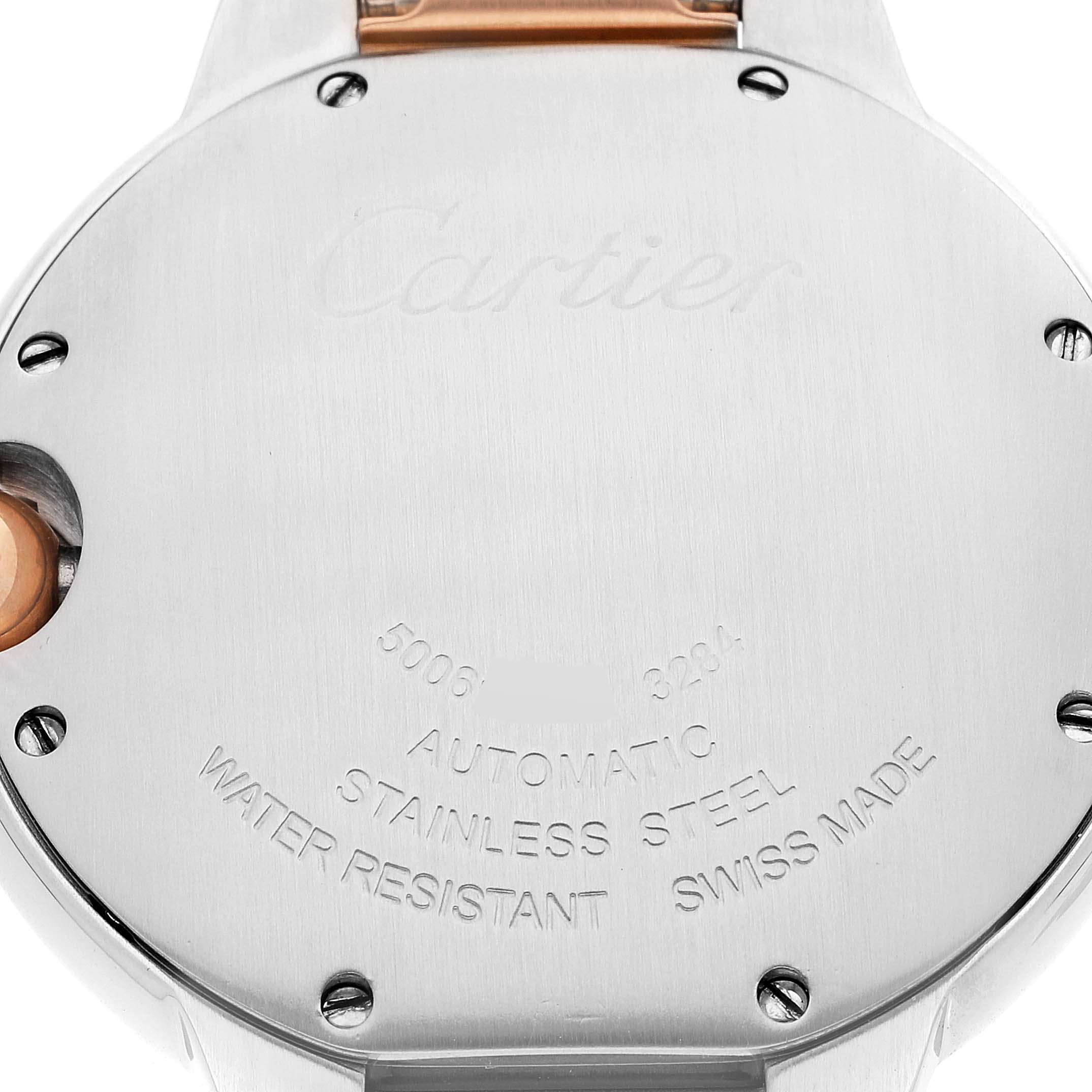 This image shows the back case of a Ballon Bleu watch by Cartier, featuring engravings and screws.