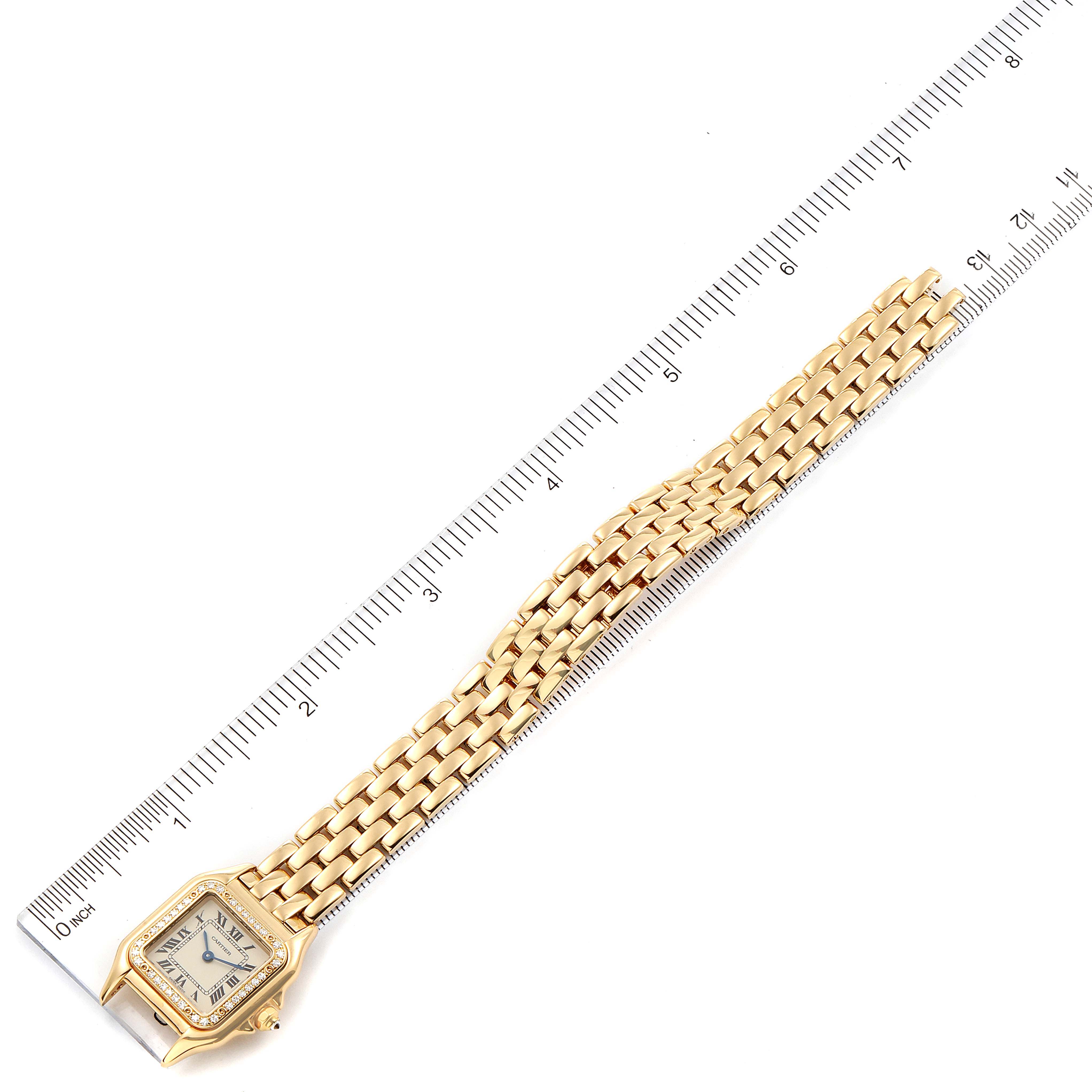 This image shows a Panthere de Cartier watch laid flat beside a ruler for scale.