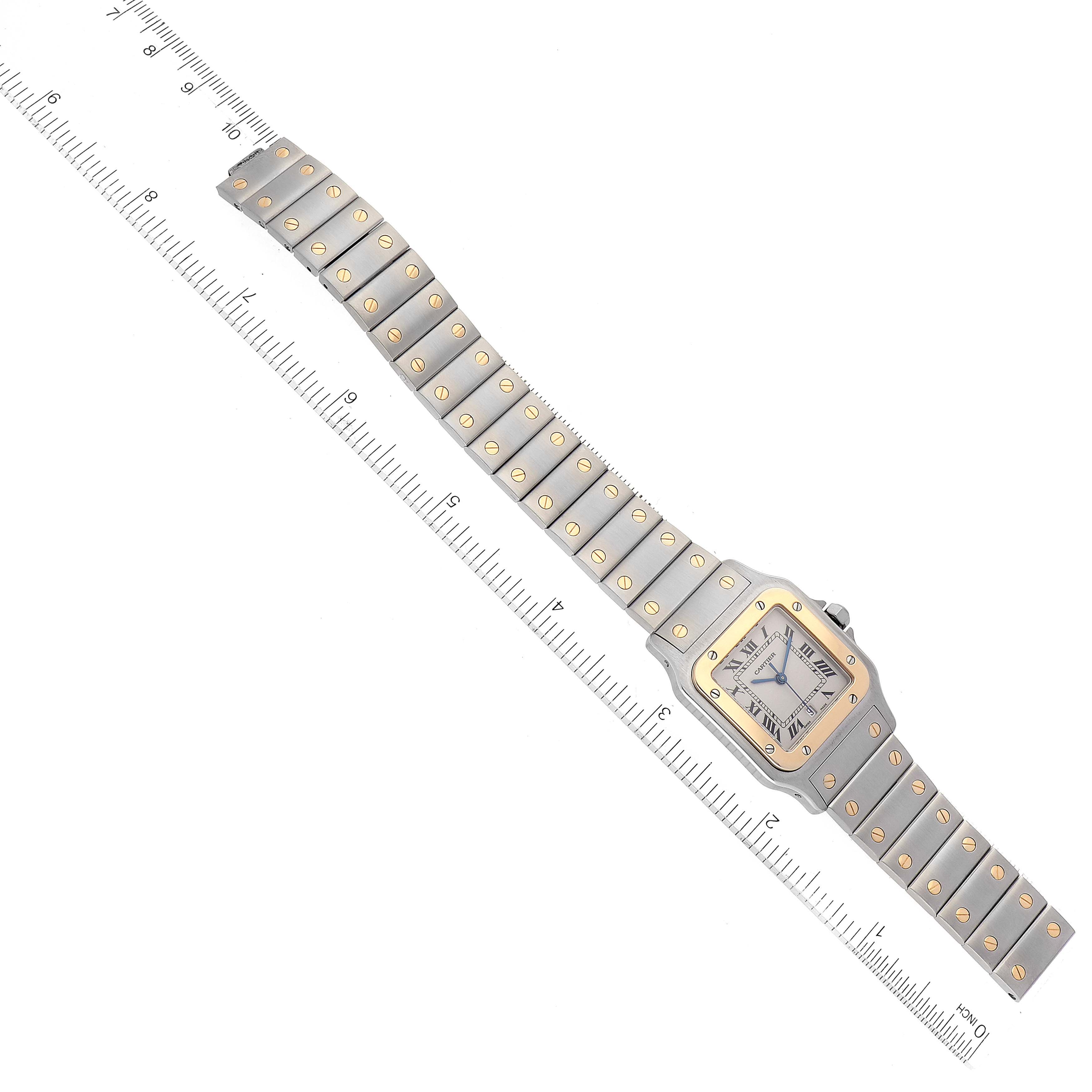 The Cartier Santos W20011C4 Men
s Steel and Gold (two tone) Silver Dial W20011C4 Men
s Steel and Gold (two tone) Silver Dial watch is shown flat, displaying the full bracelet and face, with a ruler for scale.
