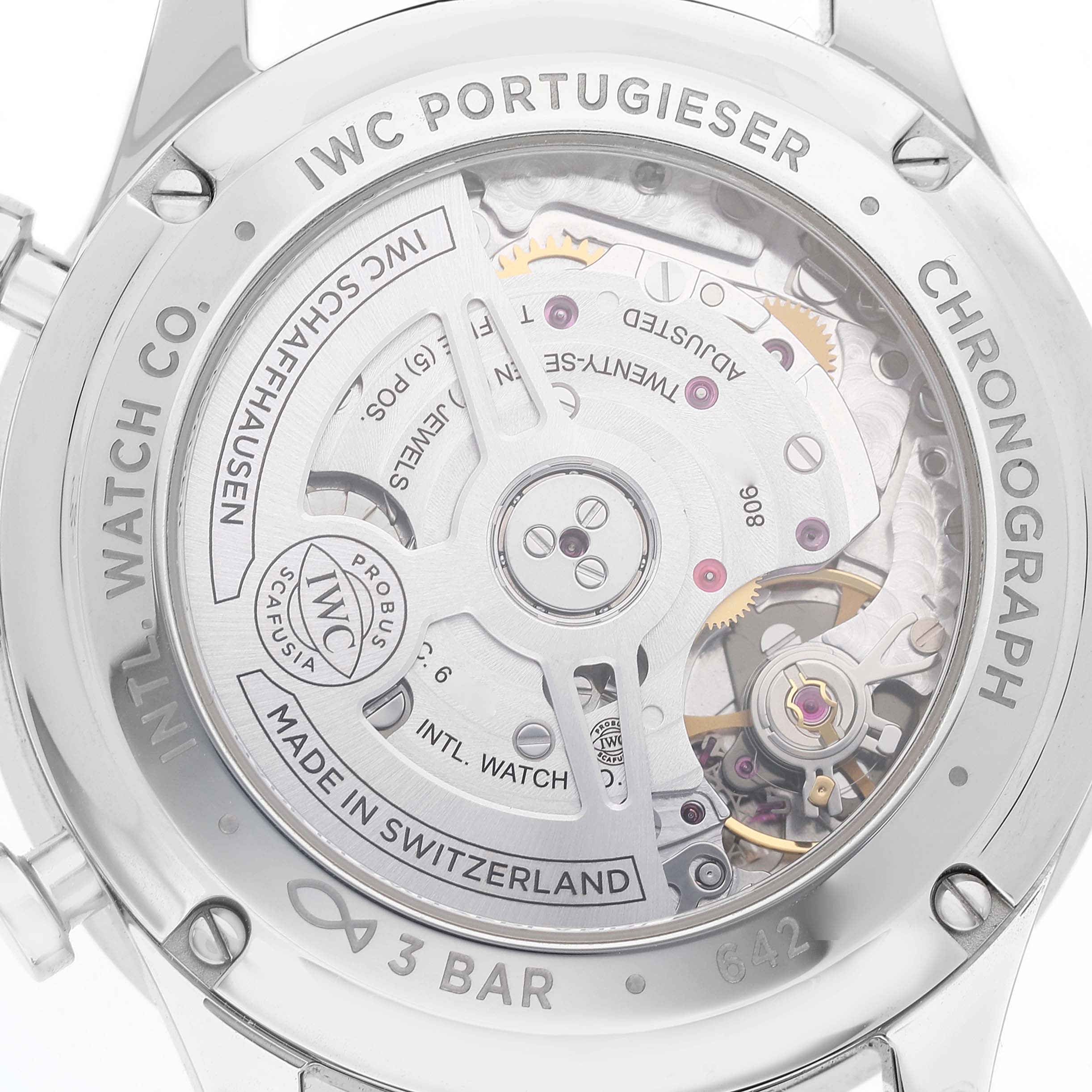 The image shows the case back of an IWC Portugieser watch, revealing the intricate movement and inner mechanism.