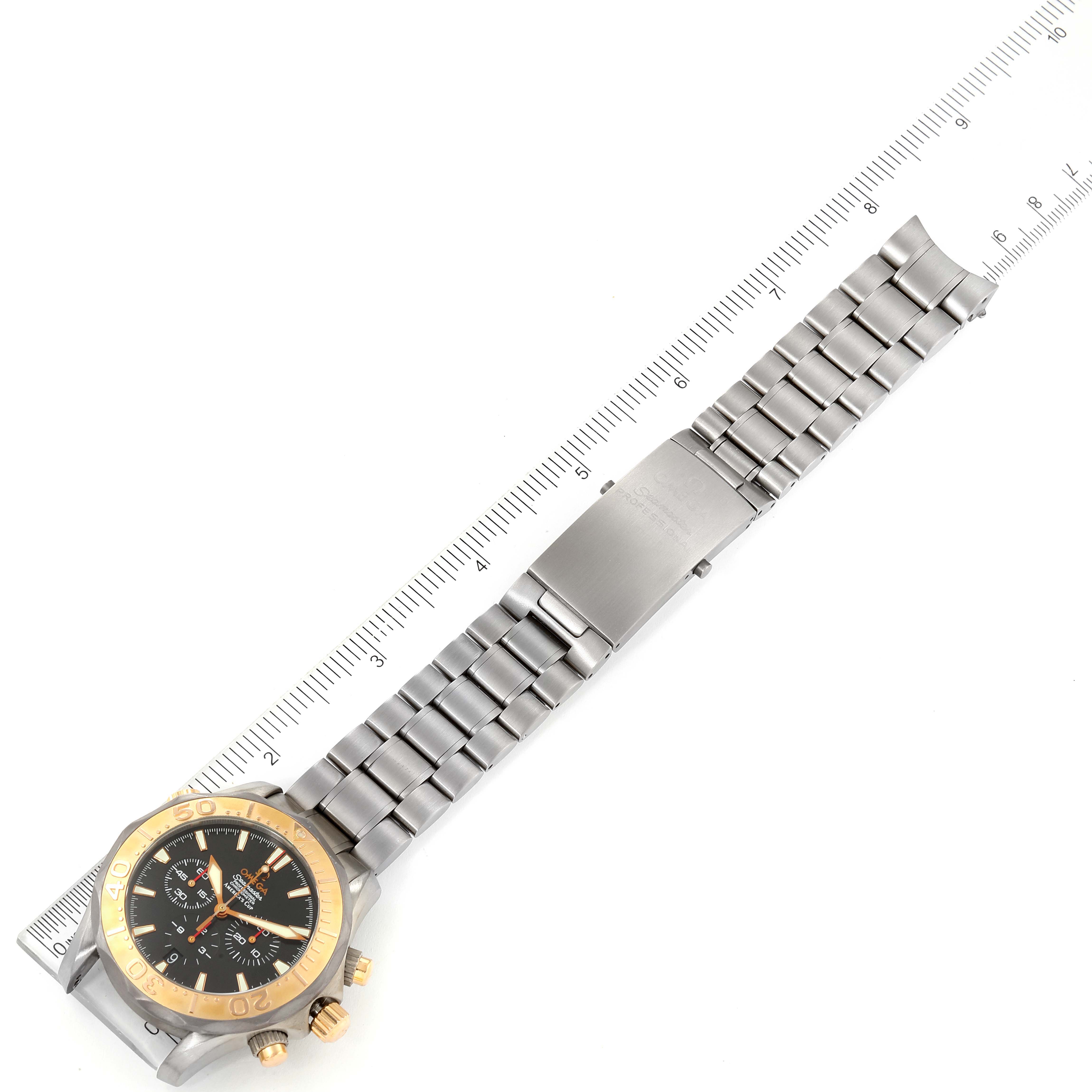 The image shows the Omega Seamaster 2294.50.00 Men's Titanium Black Dial 2294.50.00 Men's Titanium Black Dial watch laid out flat with a focus on the watch face, metal band, and clasp positioned along a ruler.