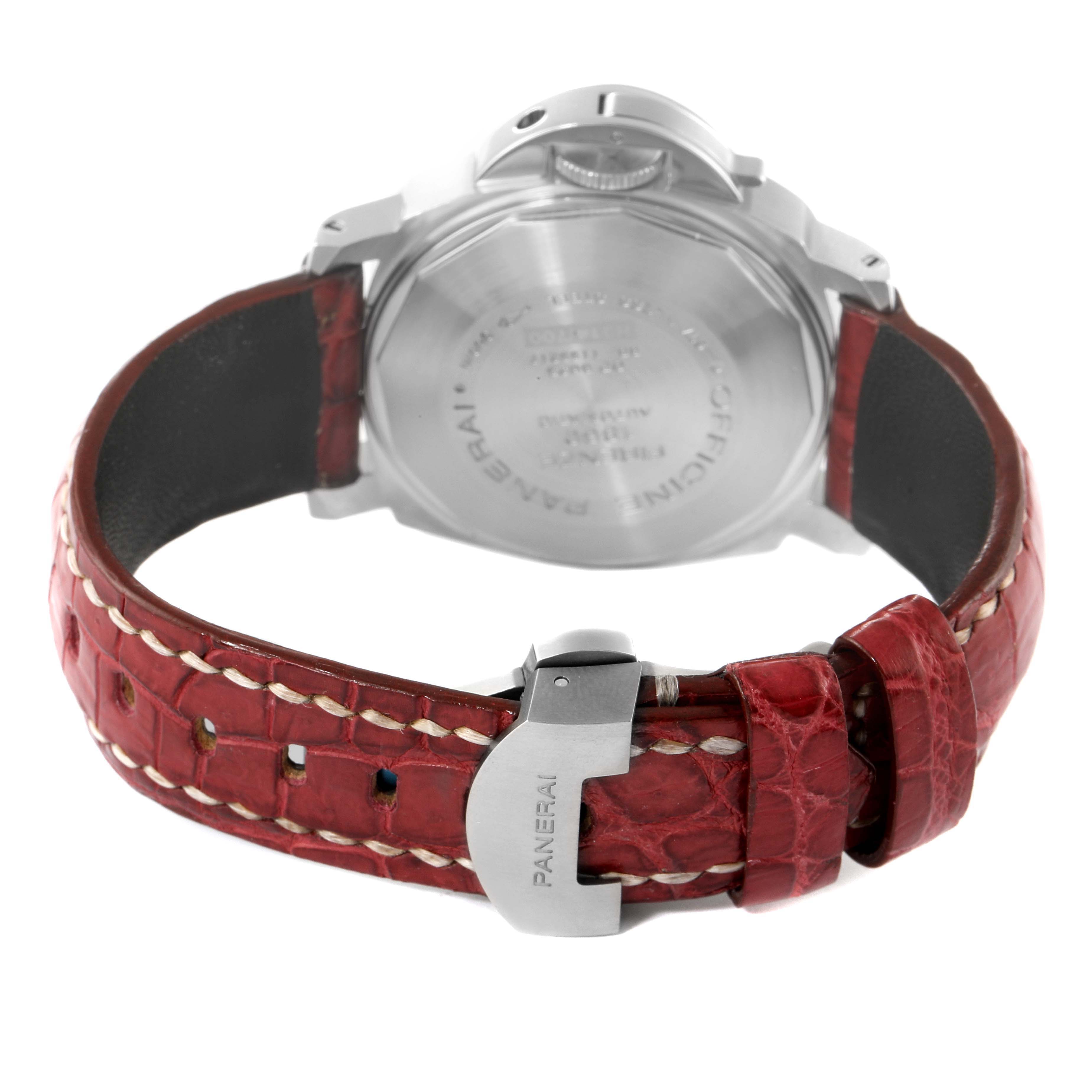 The image shows the back of a Panerai Luminor PAM00119 Men
s Stainless Steel Blue Dial PAM00119 Men
s Stainless Steel Blue Dial watch, highlighting its case back and red leather strap with a clasp.