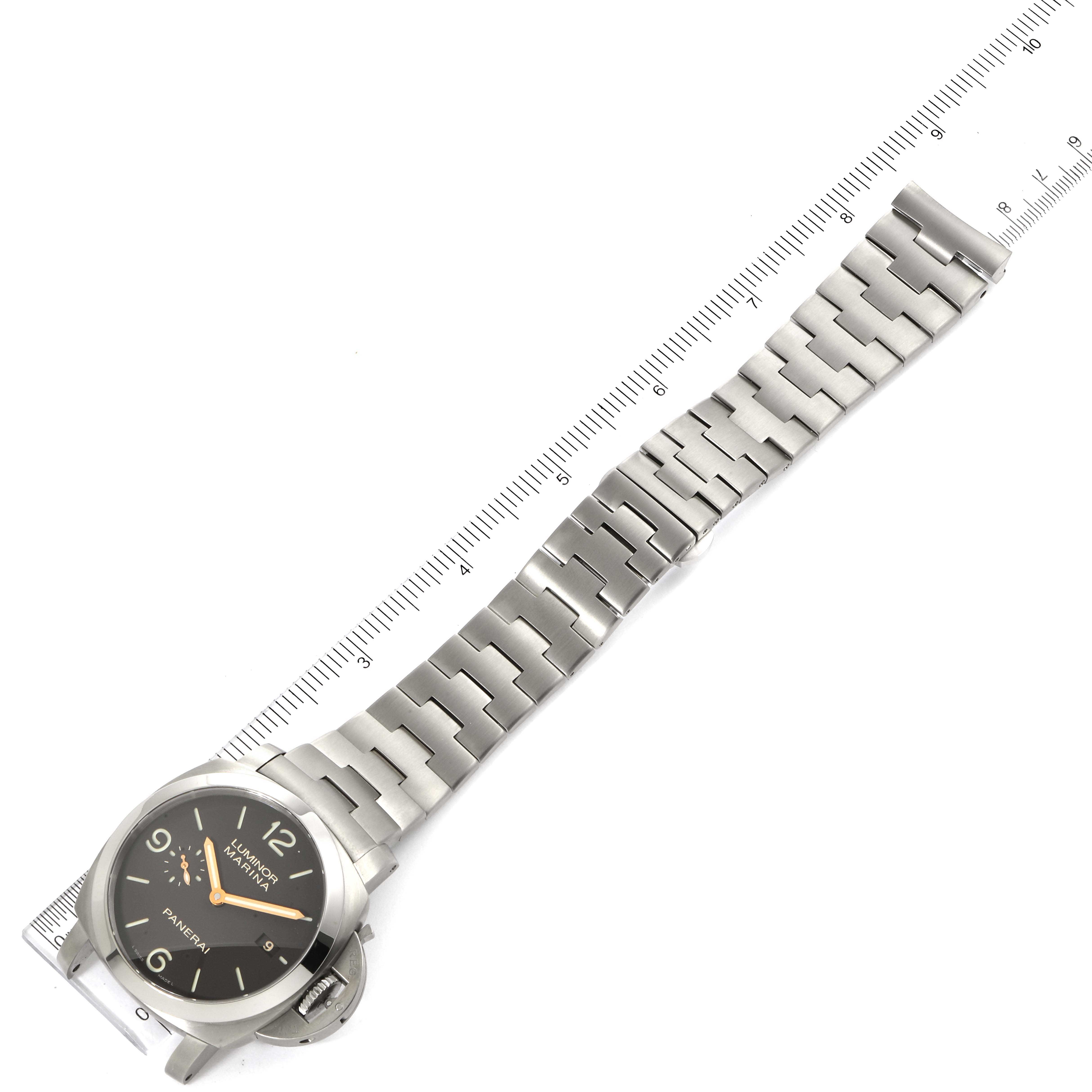 The Panerai Luminor PAM00352 Men
s Titanium Brown Dial PAM00352 Men
s Titanium Brown Dial watch is shown from a top-down angle with its dial, case, and metal bracelet visible beside a ruler.