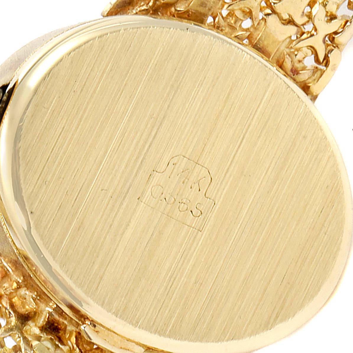 The image shows the back case of the Rolex Cocktail  Women's Yellow Gold Champagne Dial  Women's Yellow Gold Champagne Dial model watch in close-up, highlighting its gold material and hallmark.