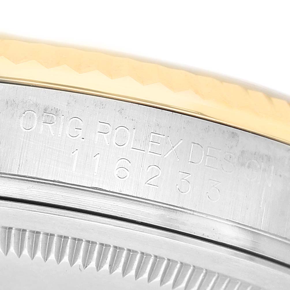 The image shows a close-up of the Rolex Datejust 116233 Men's Stainless Steel Champagne Dial model's case side with engravings and part of the fluted bezel.