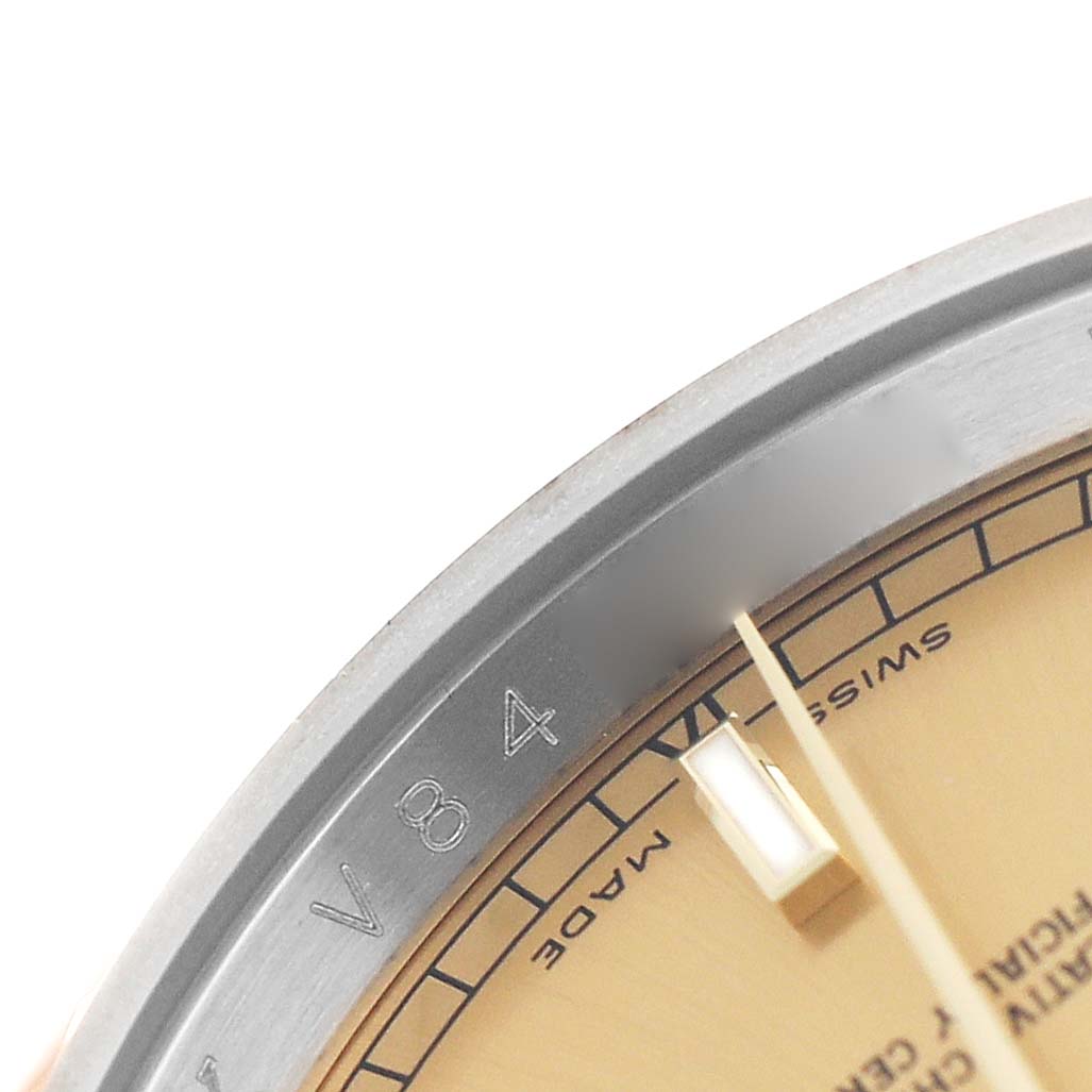 This close-up image of a Rolex Datejust 116233 Men's Stainless Steel Champagne Dial shows part of the dial, the edge of the bezel, and markings on the chapter ring.
