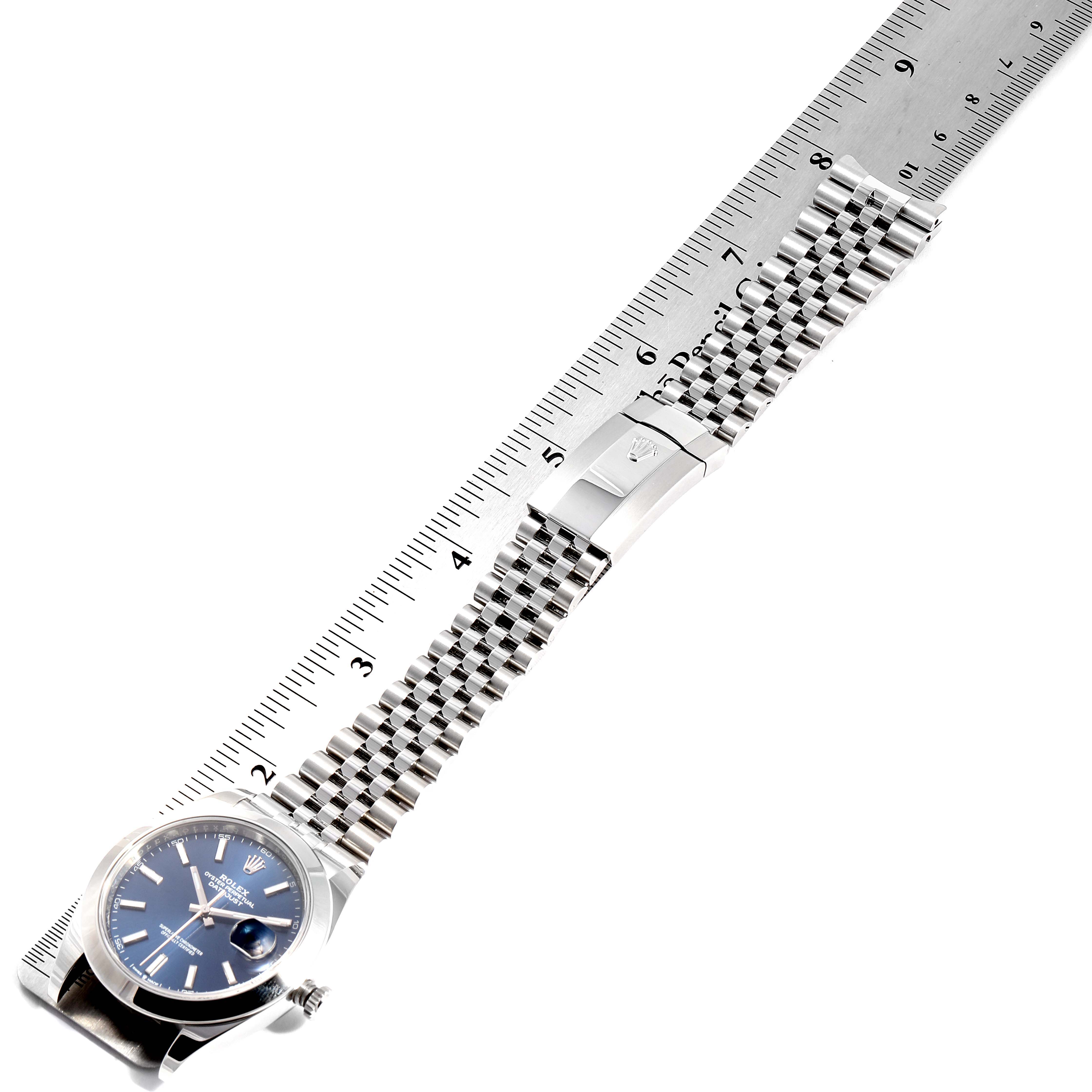 The image shows a top-down view of a Rolex Datejust 41 126300 Men's Stainless Steel Blue Dial 126300 Men's Stainless Steel Blue Dial watch, displaying the face, bracelet, and clasp against a ruler.