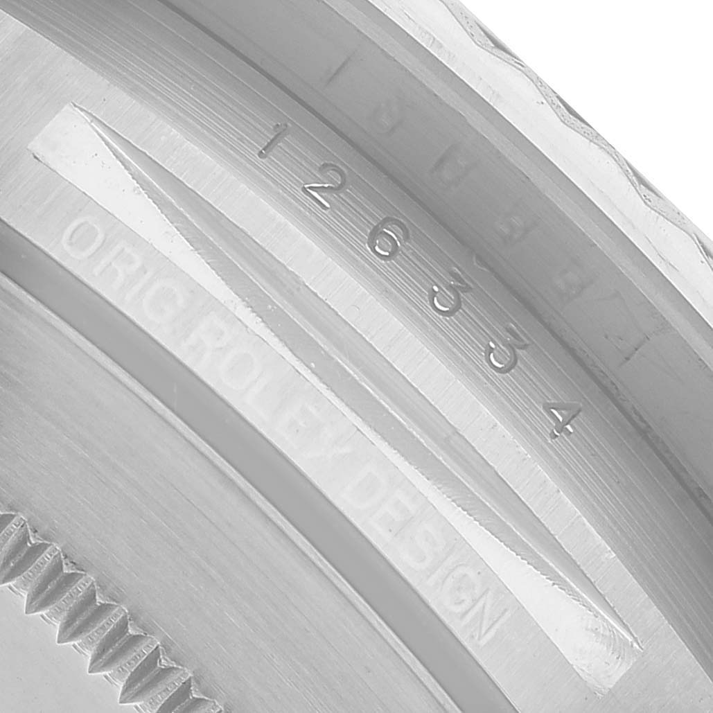 The image shows a close-up of the engraving on the inner bezel of a Rolex Datejust 41 M126334-0018 Men's Stainless Steel Black Dial, displaying text and numbers.