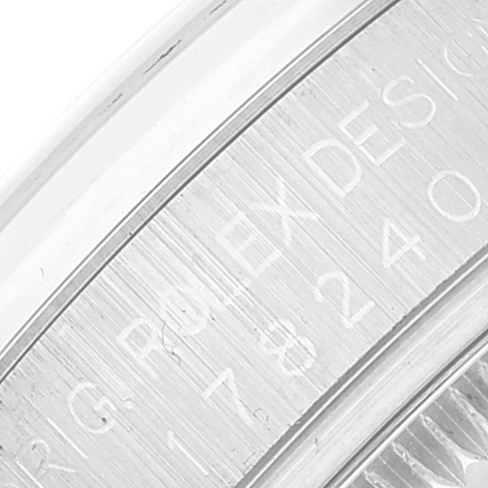The image shows a close-up of the bezel engraving on a Mid-Size Rolex watch.