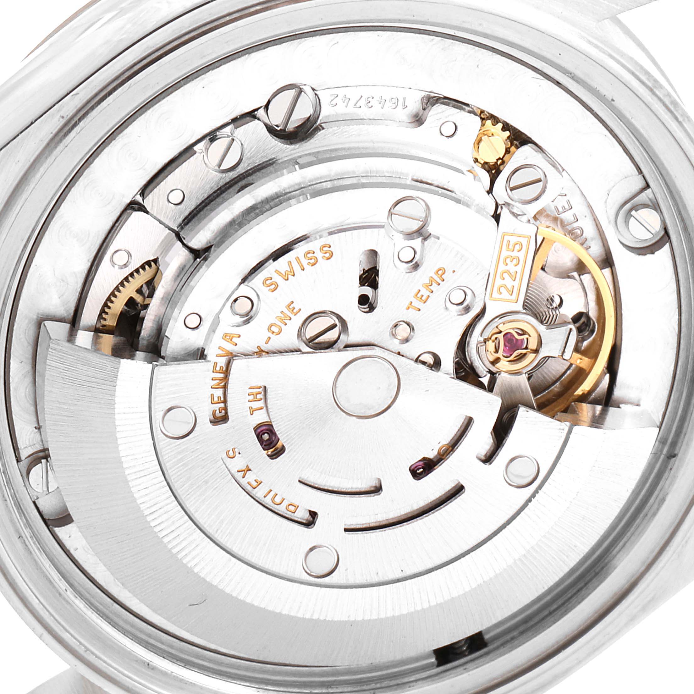 The image shows a close-up of the movement mechanism in a Mid-Size Rolex watch, displaying its intricate inner components.