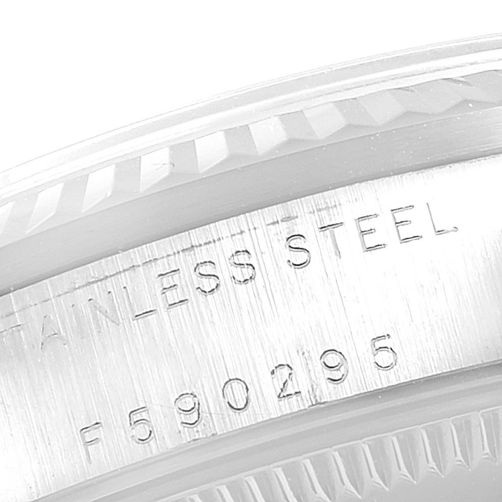 This image shows a close-up of the stainless steel casing and serial number of a mid-size Rolex watch.