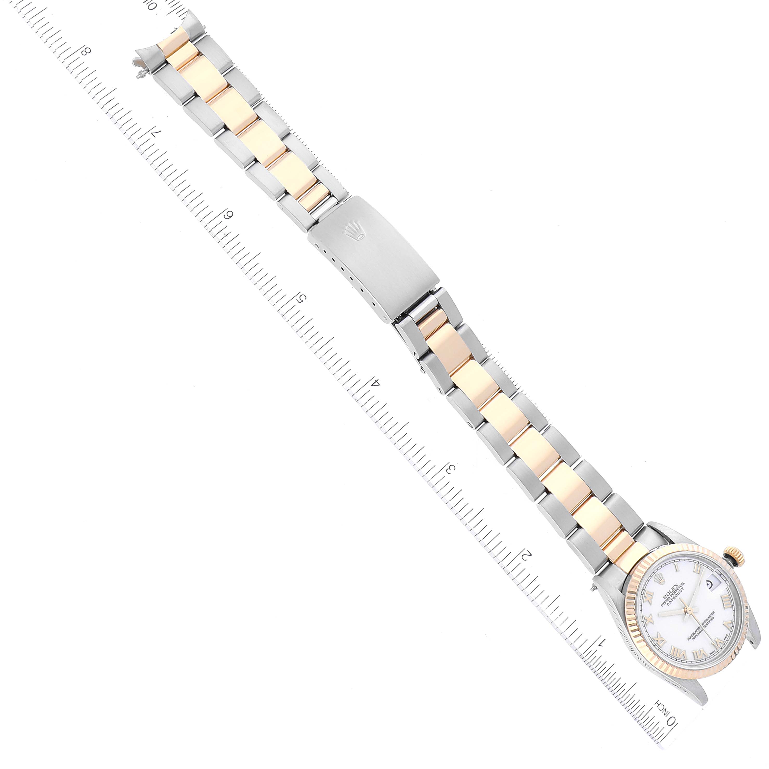 The image shows a flat-lay view of a Rolex Mid-Size 68273 Women
s Steel and Gold (two tone) White Dial 68273 Women
s Steel and Gold (two tone) White Dial watch with a two-tone metal bracelet and a white dial, next to a measurement ruler.