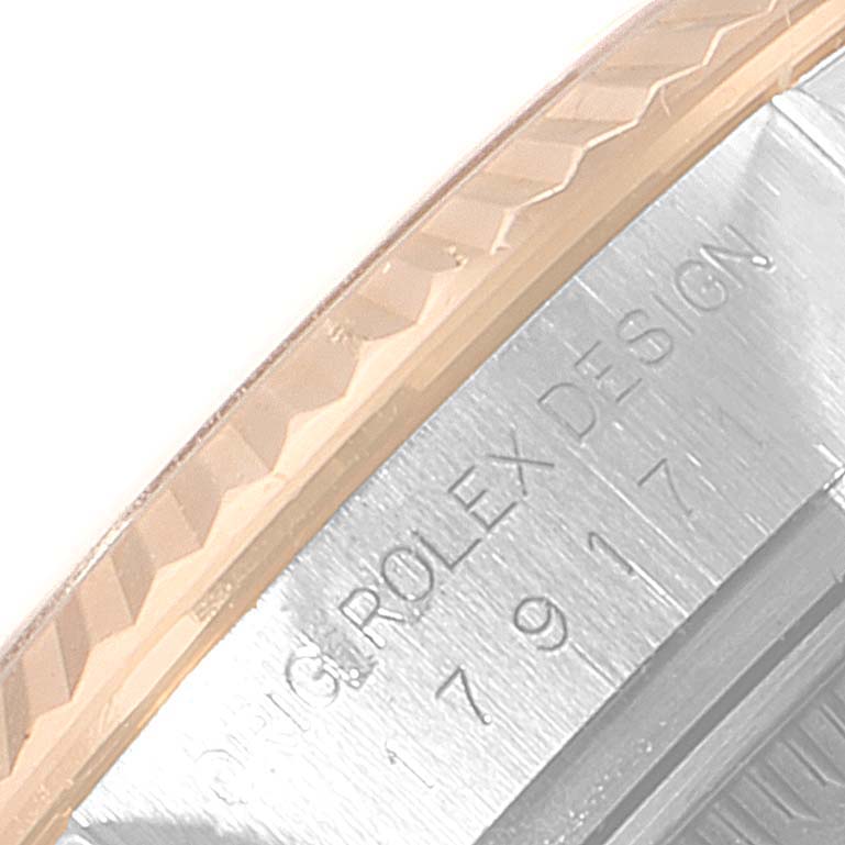 The image shows a close-up angle of the side of a Rolex Datejust 179171 Women's Steel and Gold (two tone) Silver Dial 179171 Women's Steel and Gold (two tone) Silver Dial, displaying part of its bezel and engraved text.