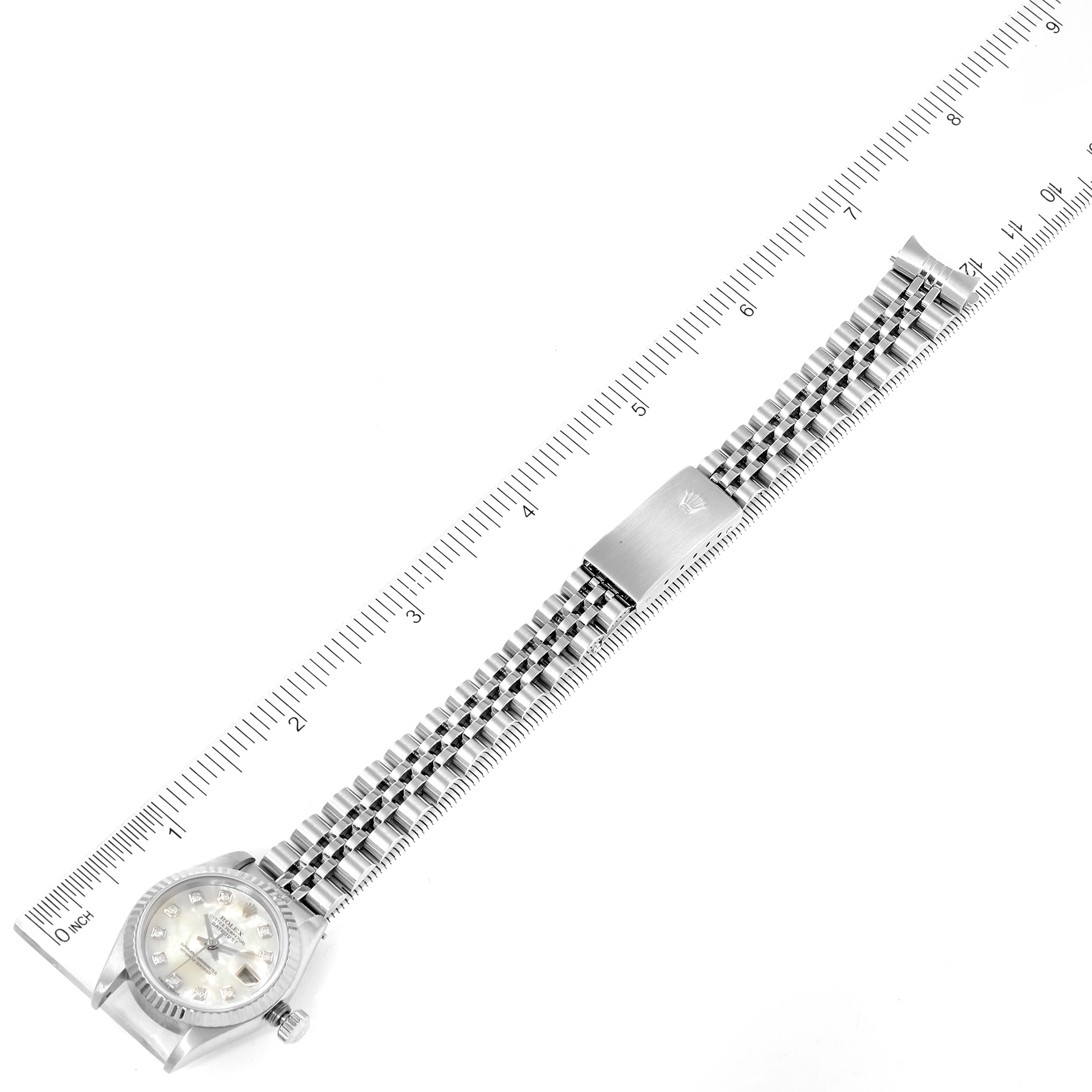 The image shows a top-down view of the Rolex Datejust 79174 Women's Stainless Steel Mother of Pearl Dial 79174 Women's Stainless Steel Mother of Pearl Dial watch, including its face, jubilee bracelet, and clasp, with a ruler for scale.